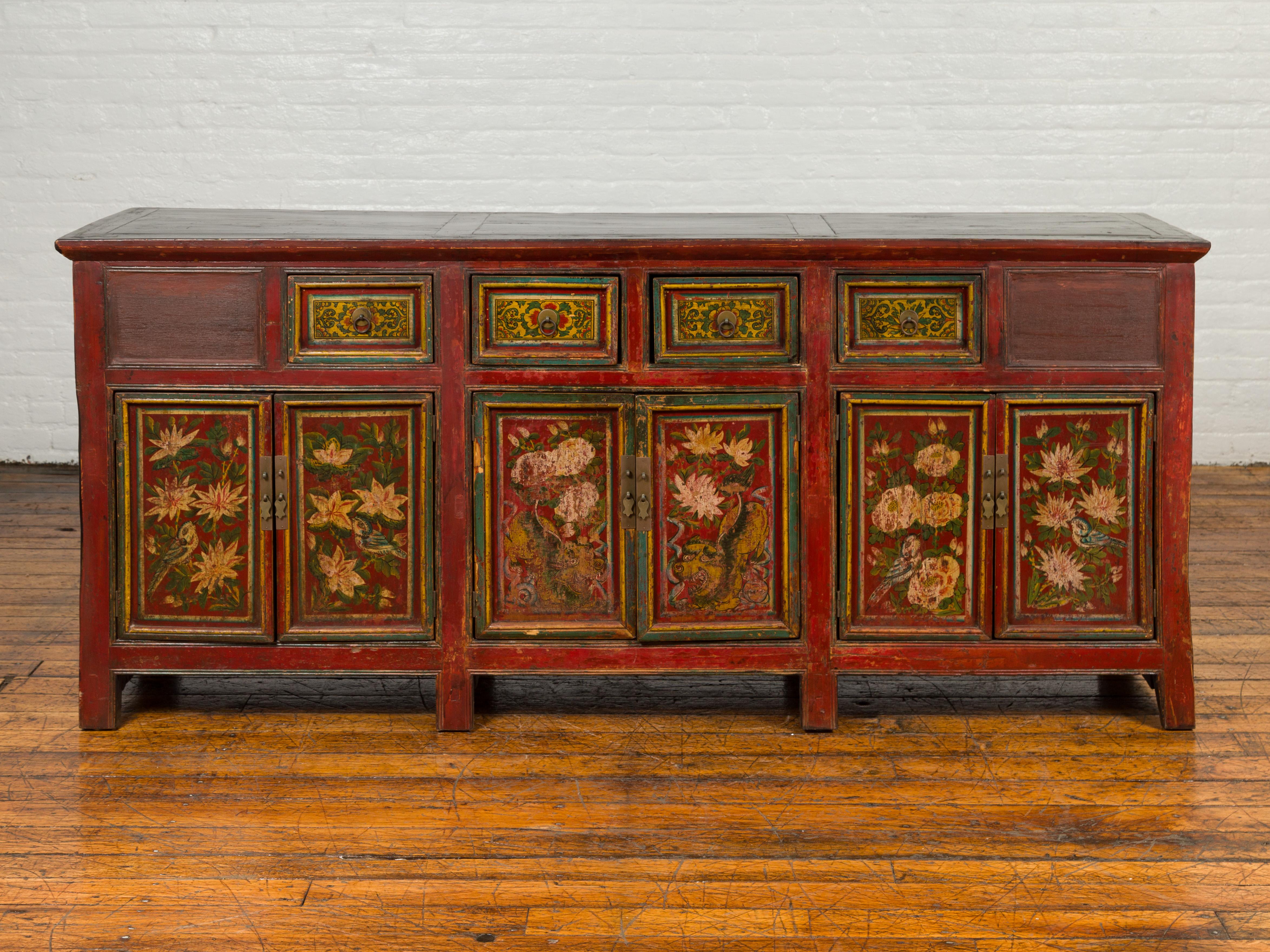 An antique Northern Chinese or Mongolian red lacquered cabinet from the 19th century, with hand painted floral decor and verdigris patina. Born during the 19th century in the Mongolian / Northern Chinese area, this exquisite cabinet features a