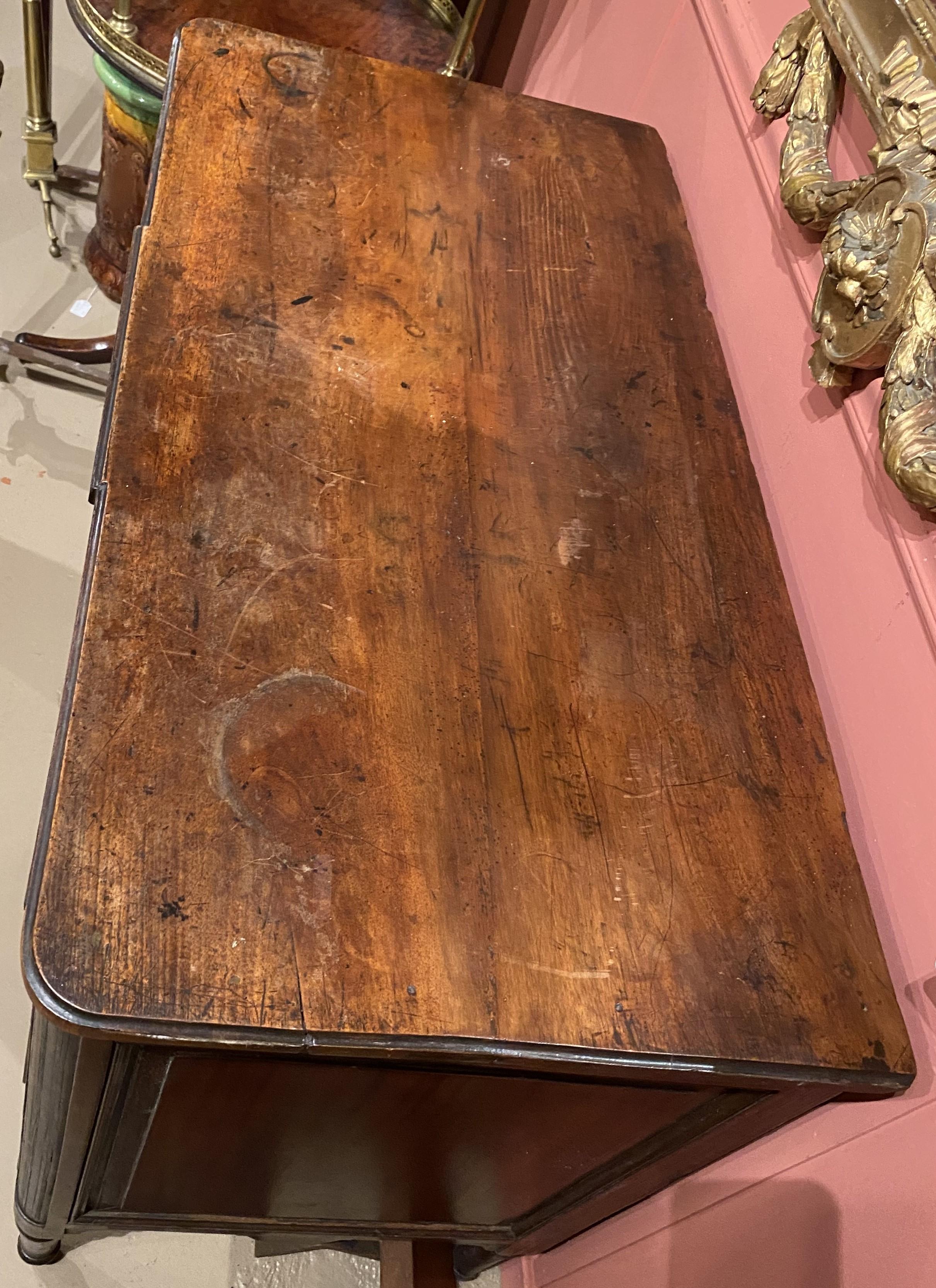 Un bell'esempio di commodo neoclassico in mogano in configurazione tre su due, con piano con bordo modanato e fronte dentellato che sormonta una cassa con frontali dei cassetti intarsiati in ebano, tiretti ad anello in ottone, angoli ribattuti e