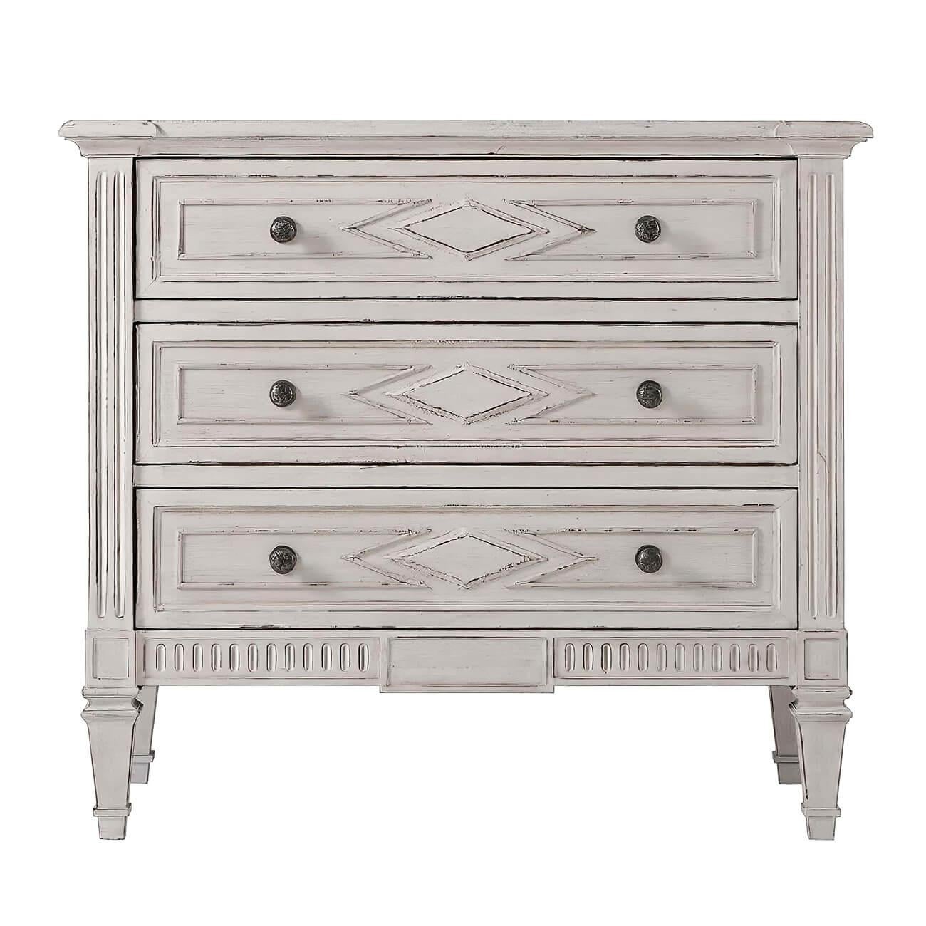 Northern European style distress painted dresser with a molded edge rectangular top, three long paneled drawers with lozenge detailing and antique pewter handles, with carved fluted details and raised on square tapered legs.
Dimensions: 36