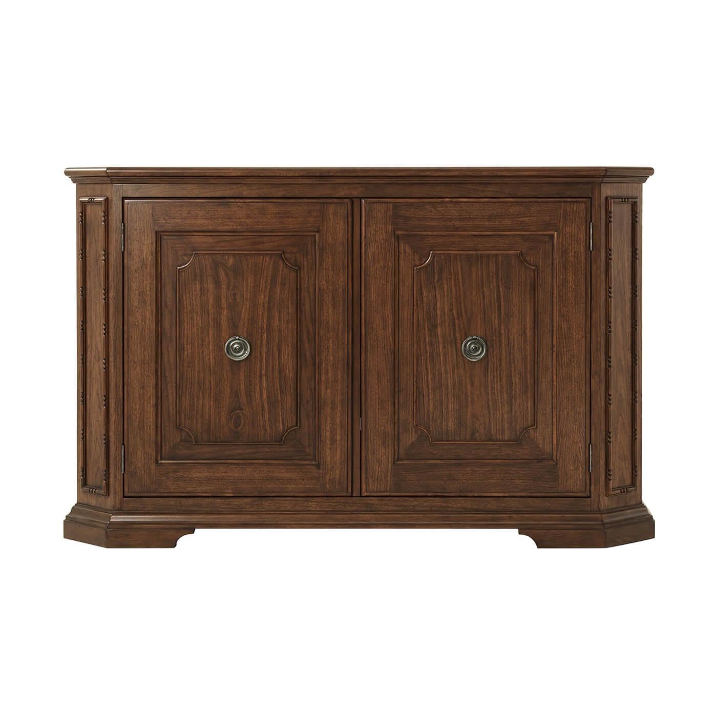 Northern European walnut buffet with a rectangular top having canted corners with paneled and angled uprights, two cabinet doors, the interior with two adjustable shelves and raised on molded bracket feet.

Dimensions: 65