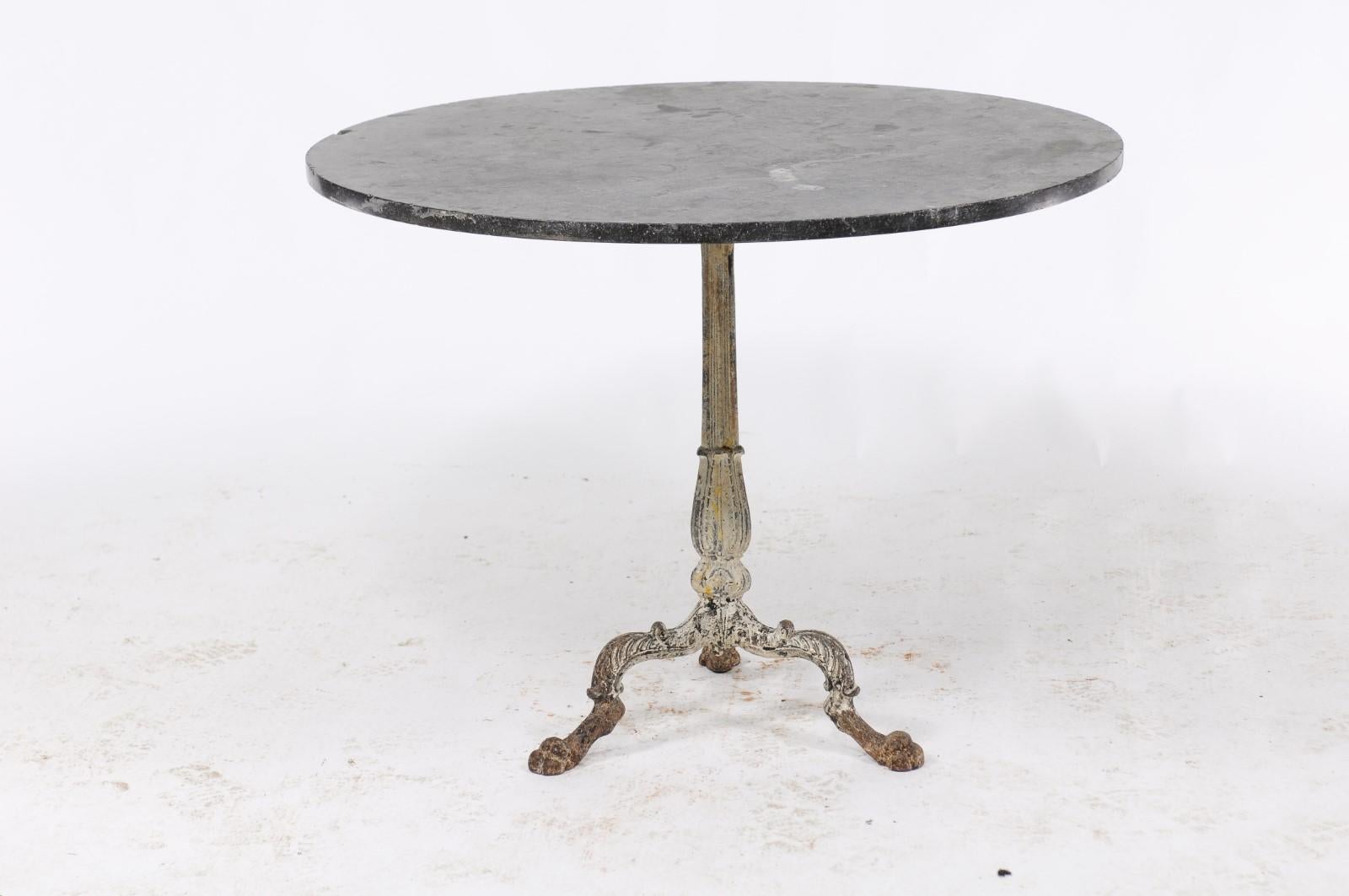 A French iron table from the early 19th century with round slate top and tripod base. From Northern France, this is an elegant round table with an intricately detailed iron base that features three legs. Topped by a beautiful grey top, this French