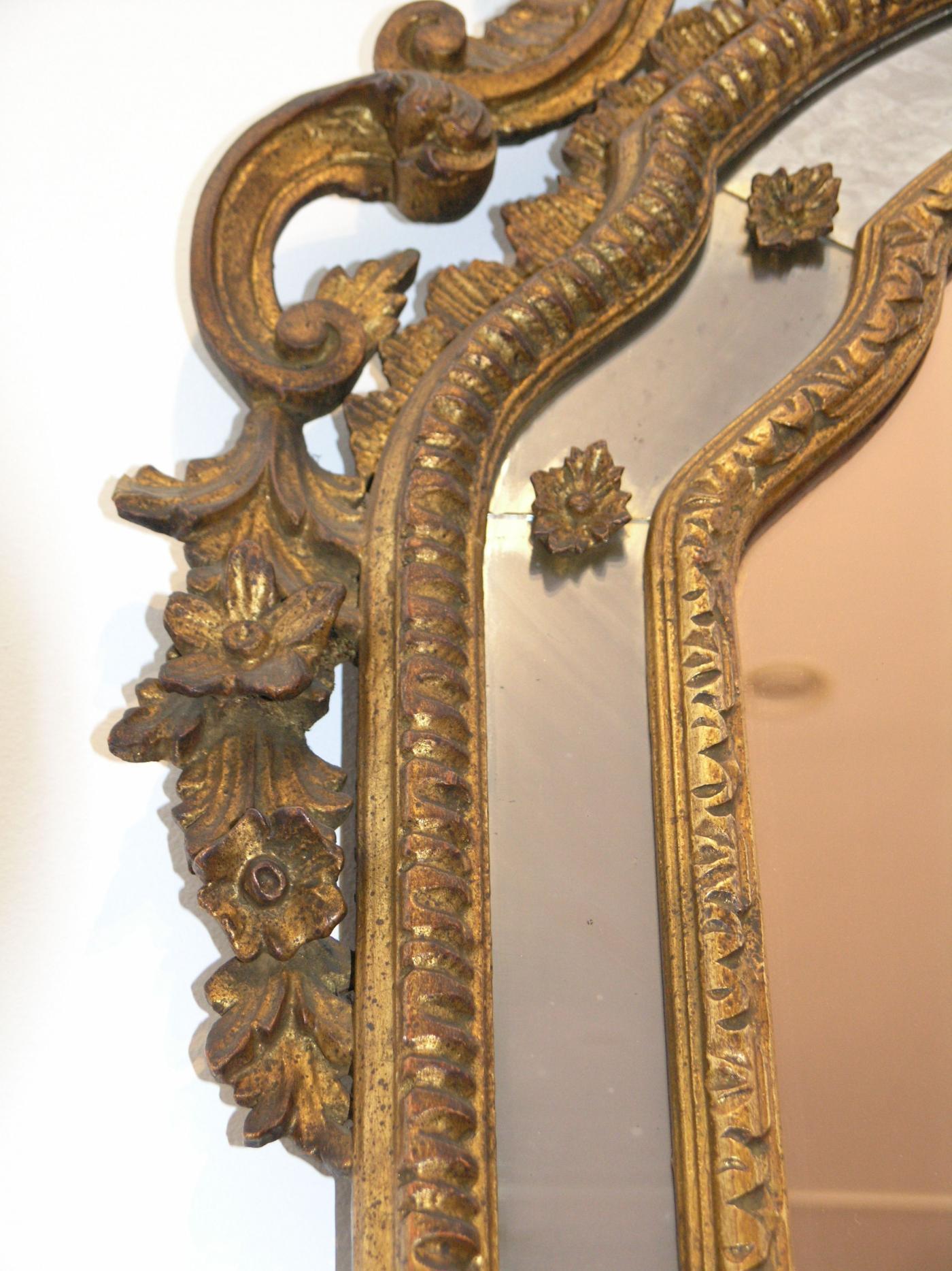 The arched plate within marginal borders and surmounted by a bold pierced foliate C- scroll cresting leading to similar pendants, on C- scroll outswept feet centered by a leafy apron.