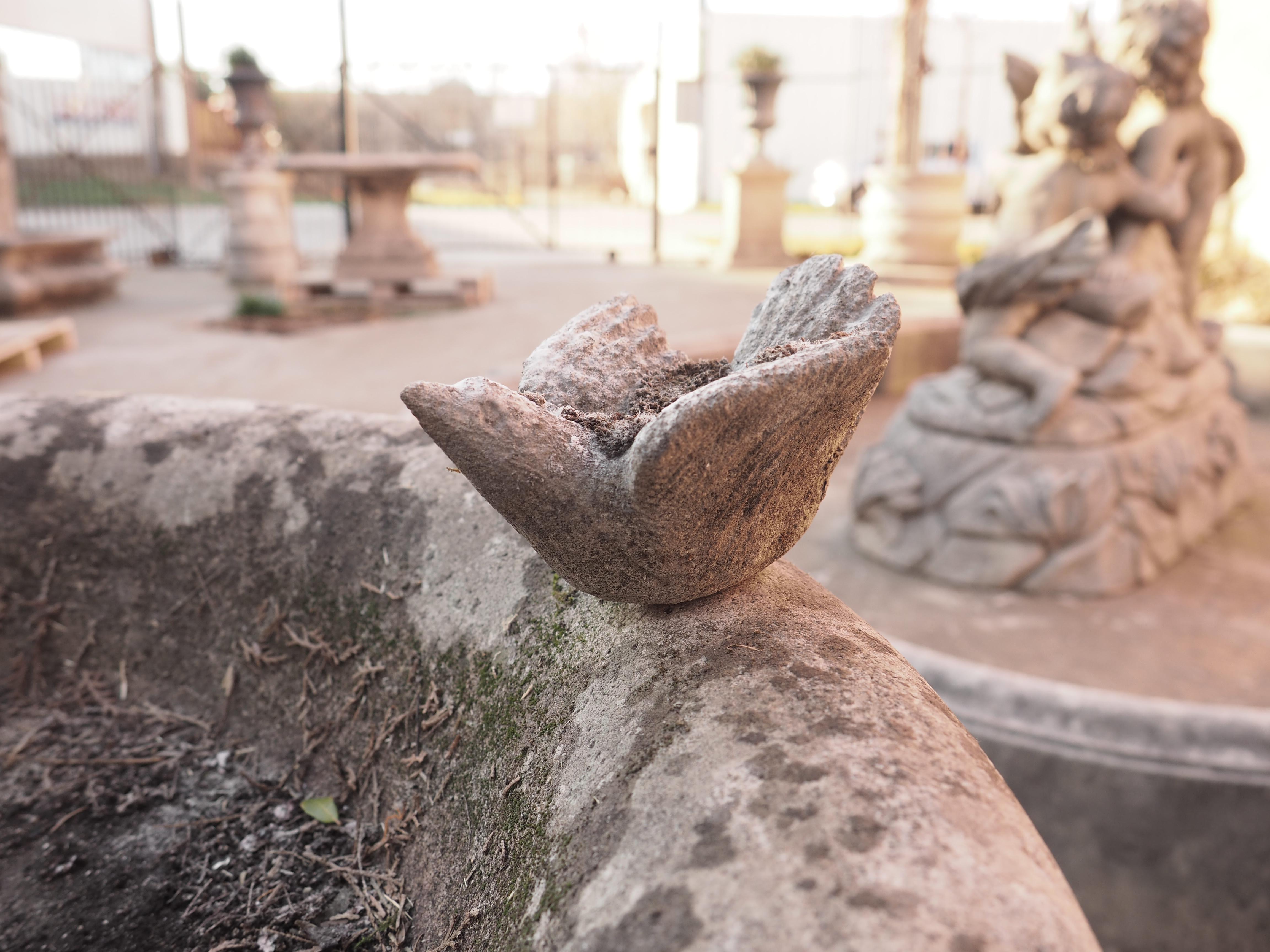 This charming birdbath was hand-carved from Northern Italian limestone and features a detachable carved bird. A metal dowel affixed to the underside of the small bird slots into a hole on top of the 24” diameter basin. The rim of the bowl has