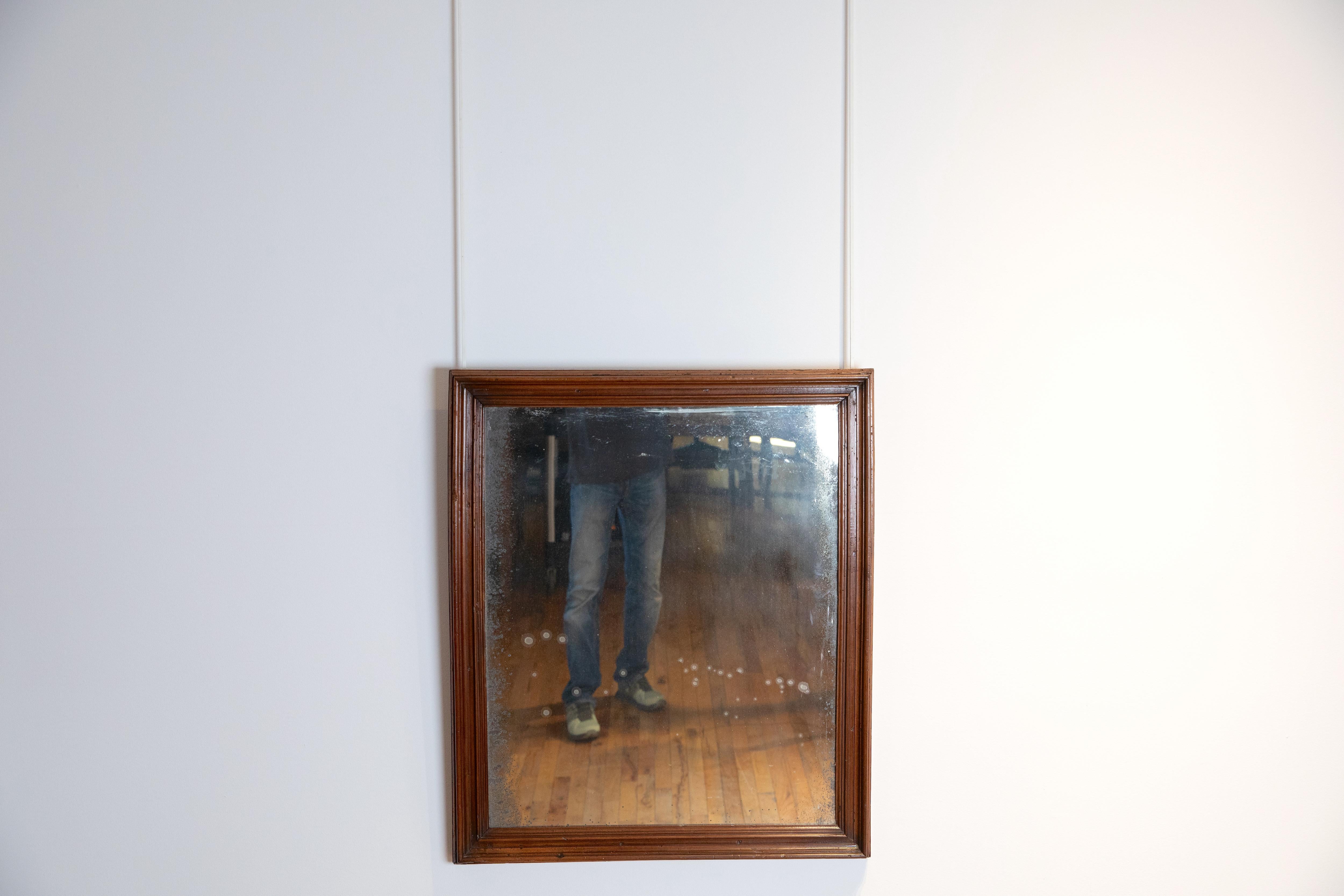 Ce cadre en noyer massif du début du XVIIIe siècle a conservé sa plaque de miroir d'origine, avec une série de bords moulurés.
