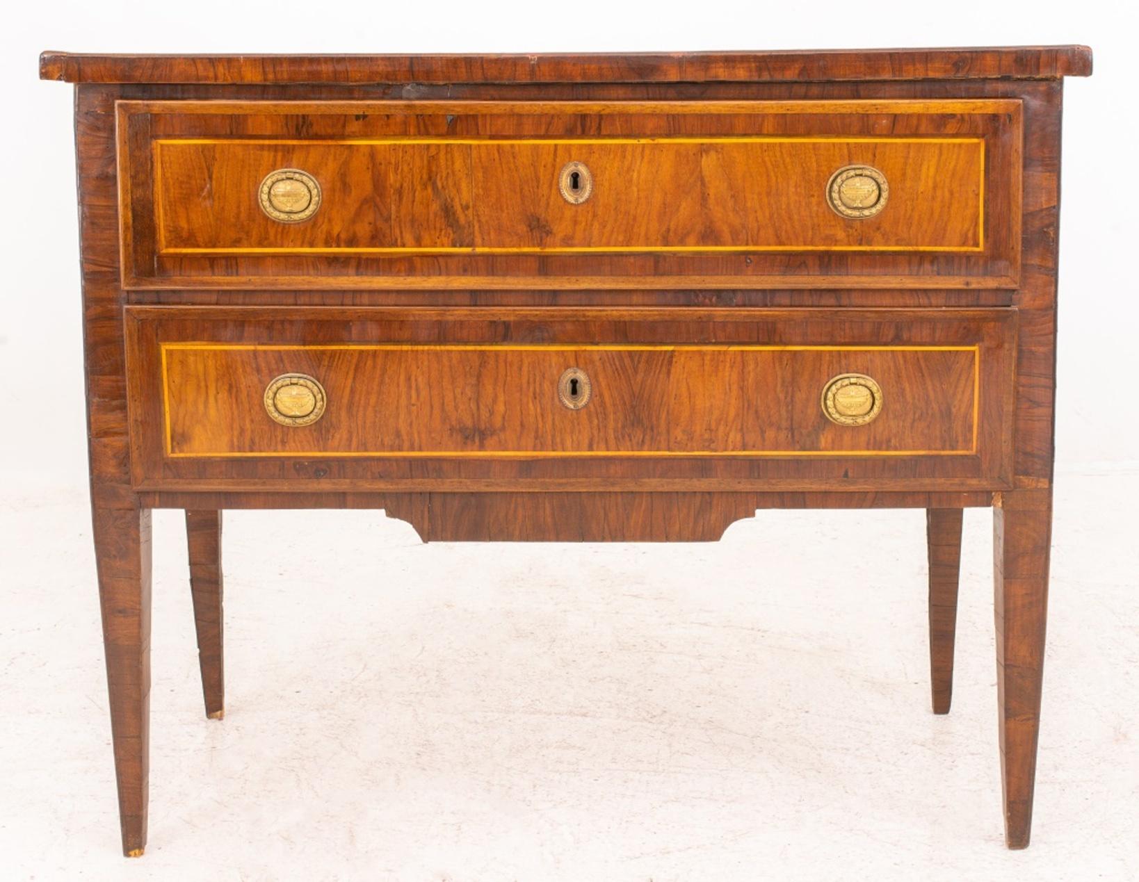 Northern Italian Neoclassical two-drawer commode, the whole veneered in walnut, with the rectangular top above two long drawers with wreath-form pulls, the whole on tapering square feet.

Dimensions: 34
