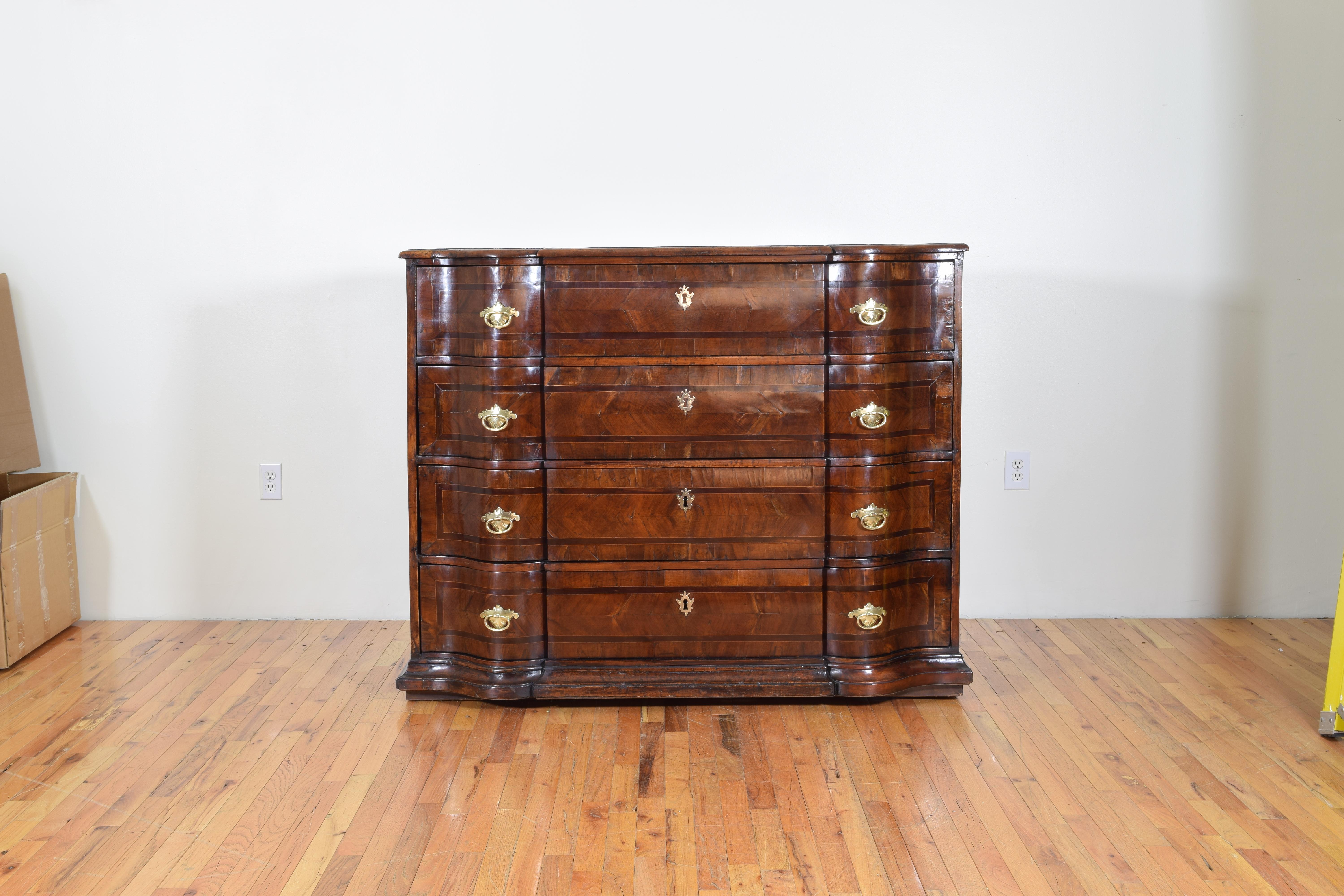 This magnificent commmode has a top shaped in the form of an archer's bow slightly rounding back and then straightening at the corners, the confomring case housing 4 drawers and having a plinth base atop hidden riser feet, the commode is sheathed in