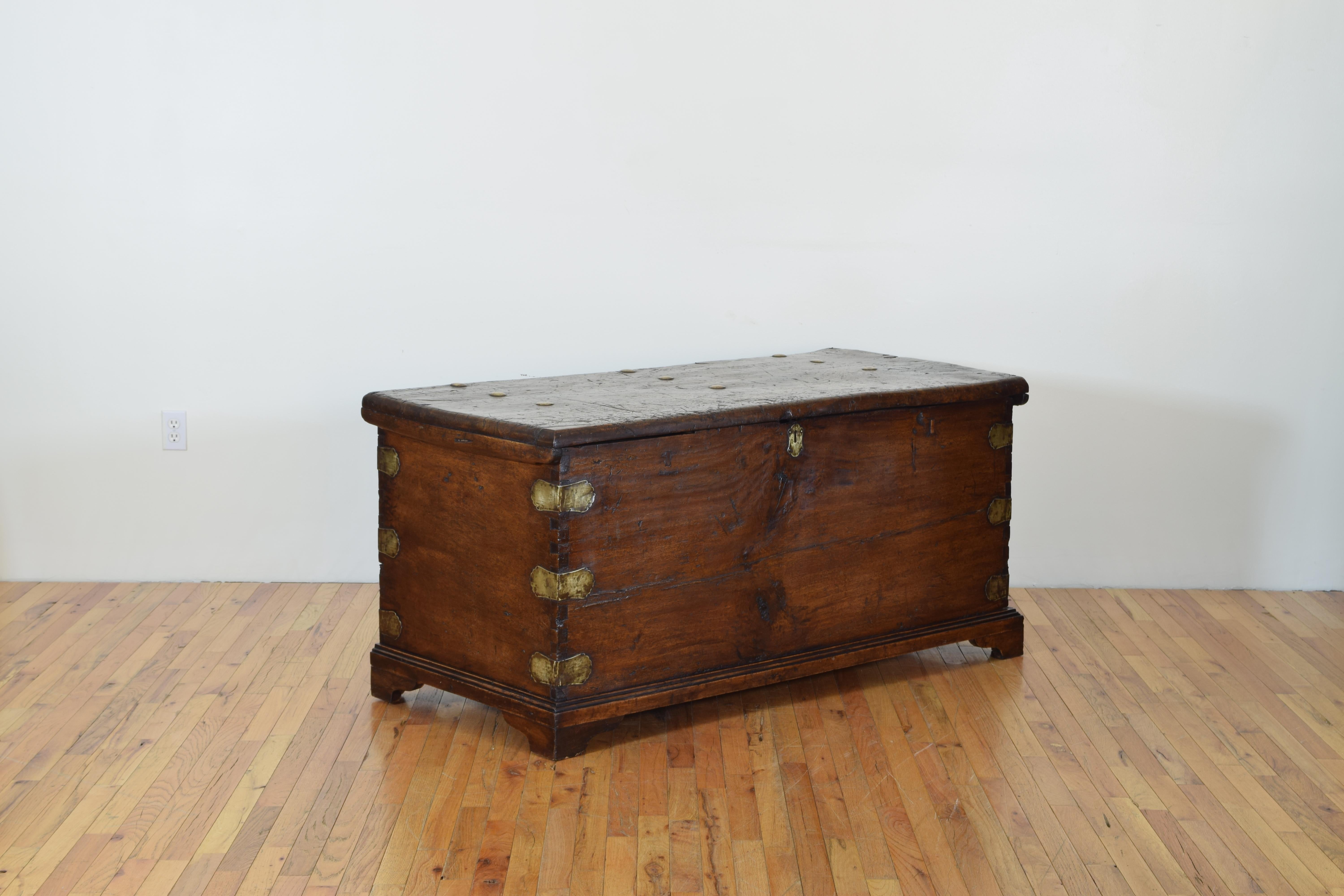 The top and sides all made from individual solid boards, with dovetail construction at the corners, seemingly the brass elements (corner bands and giant nailheads) added later in the 18th century.