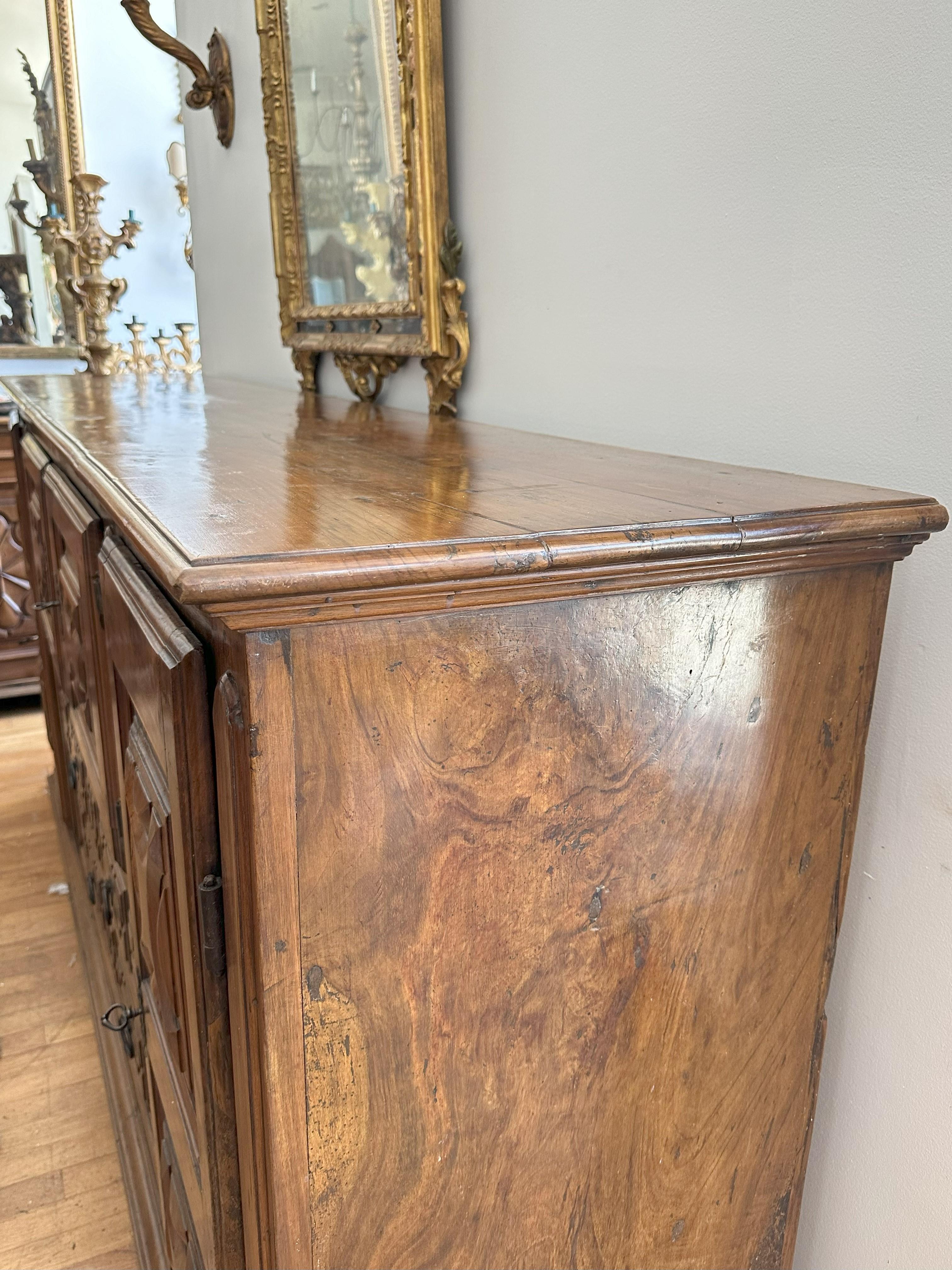 Rectangular top with molded edge conforming case fitted with two drawers and four paneled doors carved with geometric motifs , raised on a molded plinth base 