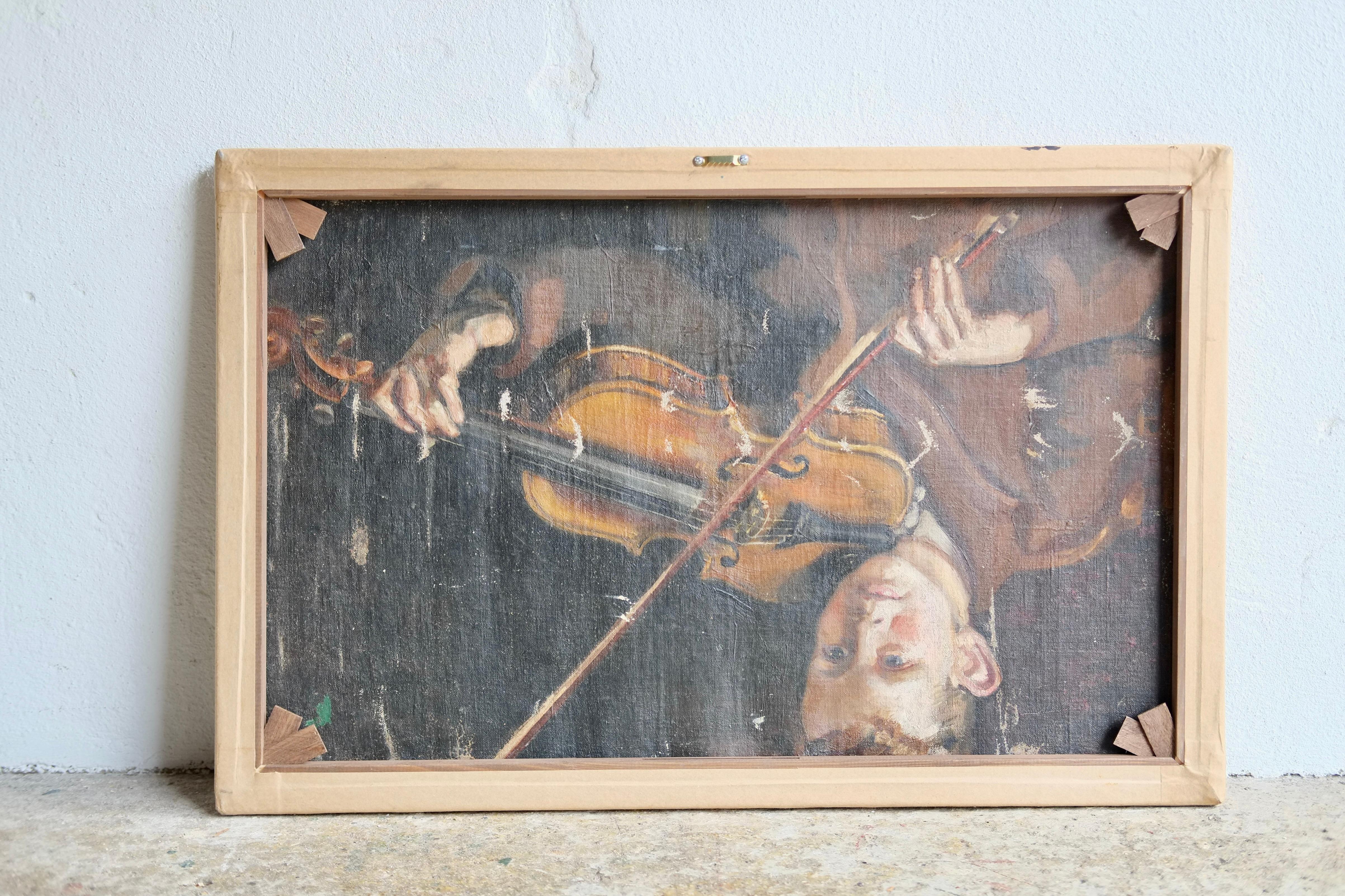 An unsigned 20th century northern school oil on canvas oil on canvas of labourers in an industrial setting. There is a study of a young boy playing the violin verso.

In good condition with no damage or loss of paint. 