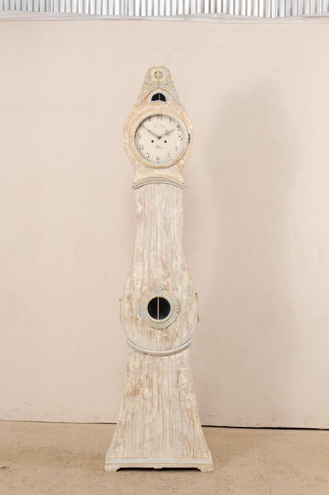 A 19th century Northern Swedish painted wood grandfather clock. This Swedish clock from Norrbotten County, Sweden (Northern region) features a nicely carved, exaggerated and raised crest of opened, elongated petals with pierced carved small flower