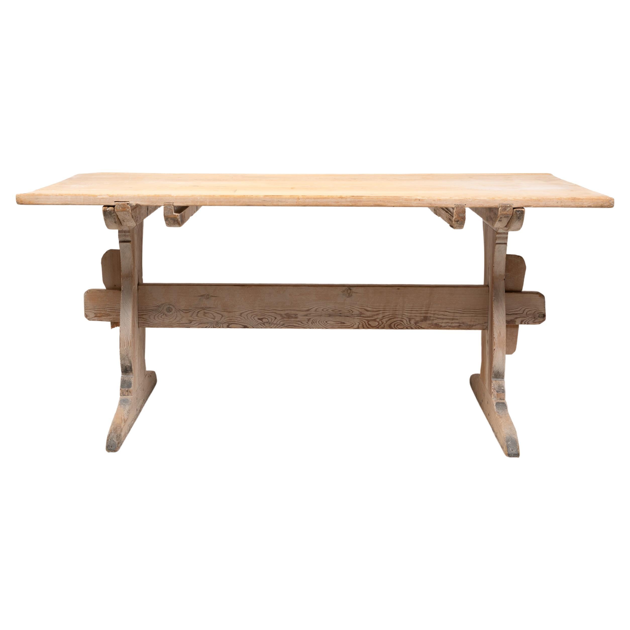 Table de salle à manger de maison de campagne suédoise en pin. Cette table, appelée table à tréteaux, est un authentique meuble de campagne du nord de la Suède, issu de l'art populaire. Fabriquée entièrement à la main, la table date de la fin des