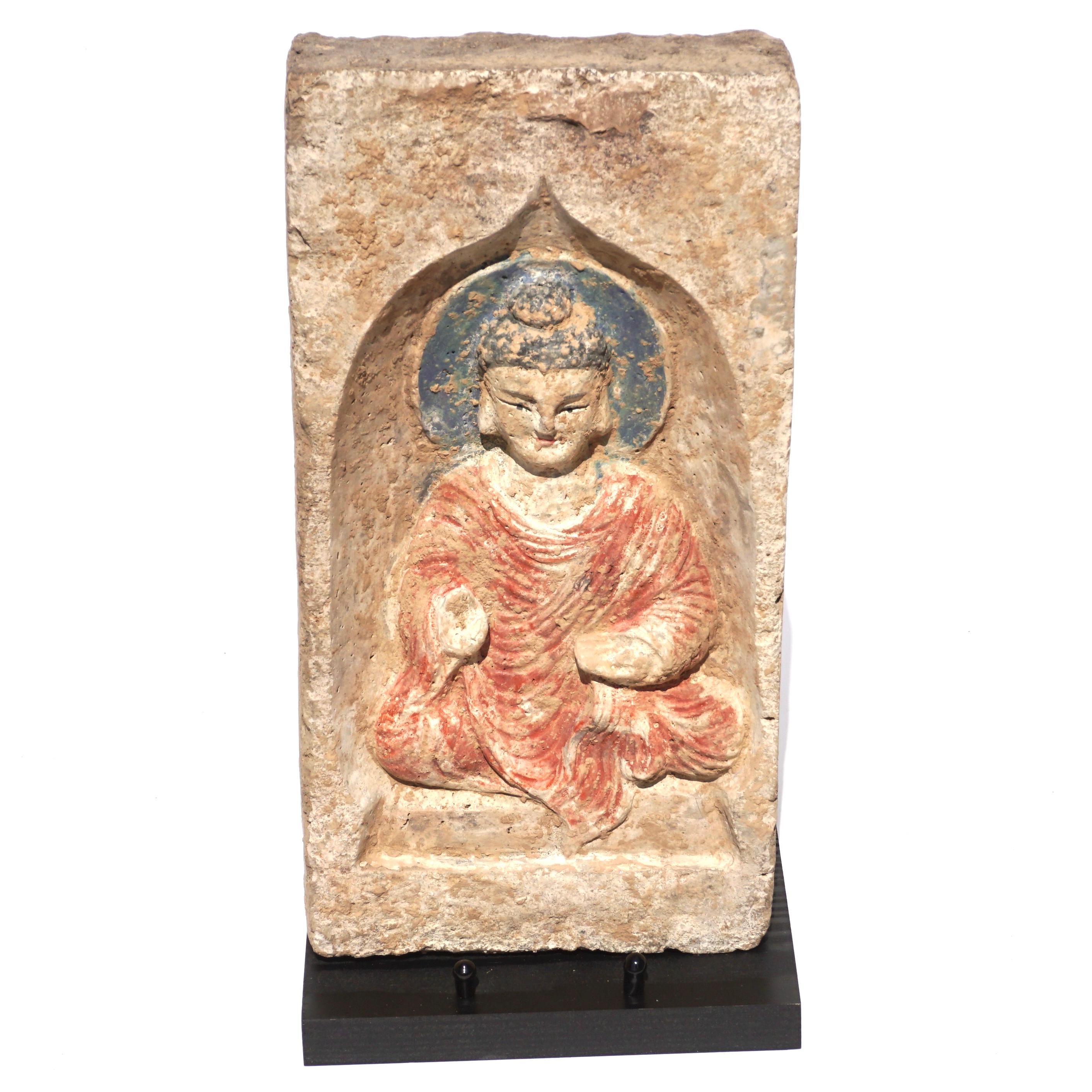C. 386-534 AD. Chinese Northern Wei Dynasty. 

A interim Han-Tang Dynasty terracotta brick in a cream-coloured fabric featuring a beautiful depiction of a seated Buddha with a red robe, black hair and blue halo. The figure has a raised right hand,