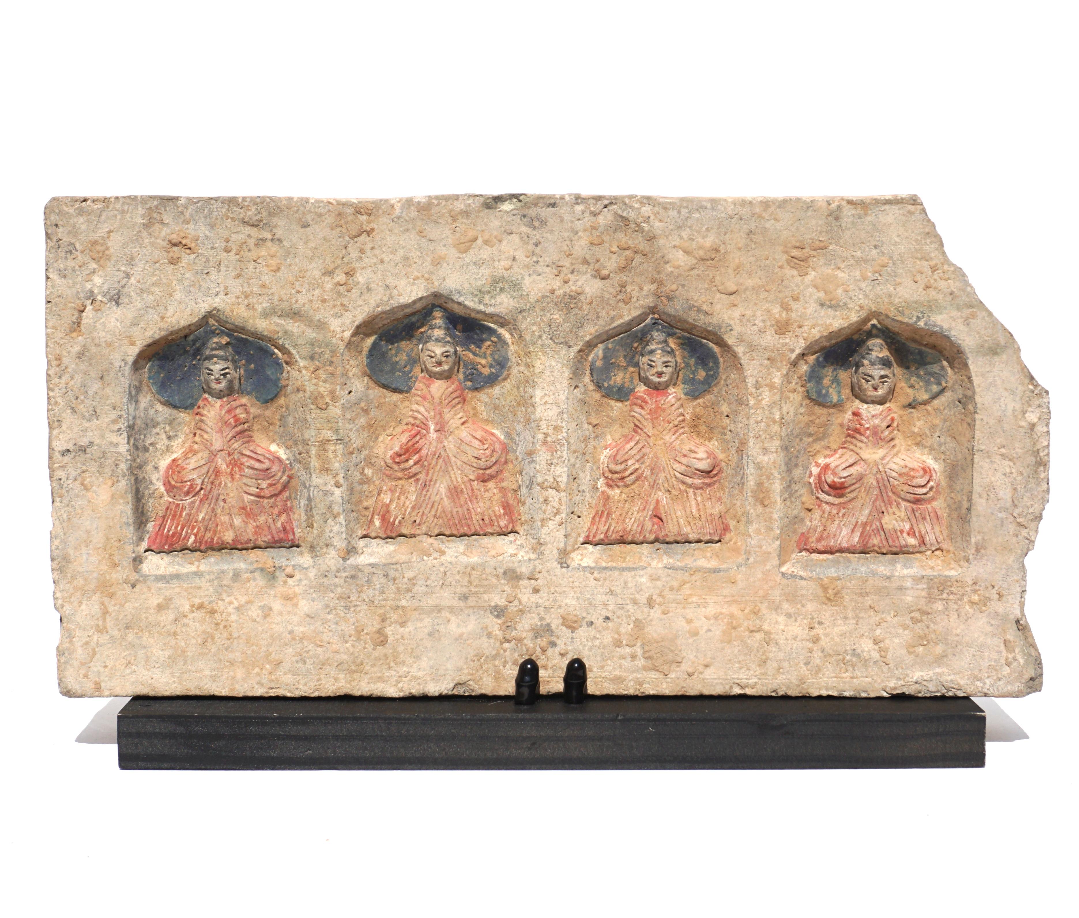 C. 386-534 AD. Northern Wei Dynasty. 

A pre Tang Dynasty Terrecotta brick featuring four painted Buddhas within an arched recess. All four Buddhas wear red robes, and sit cross legged atop a dark-coloured carpet, and against a dark background. All