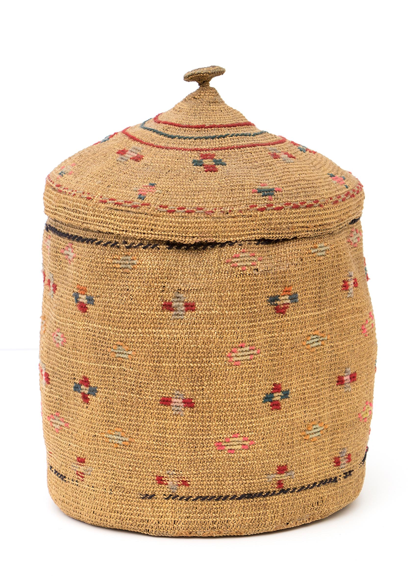 Lidded basket very finely woven of native grasses incorporating geometric designs including crosses of red, gray, green and yellow yarns circa 1900

Basket is in very good antique condition - please contact us for a complete condition report.

The