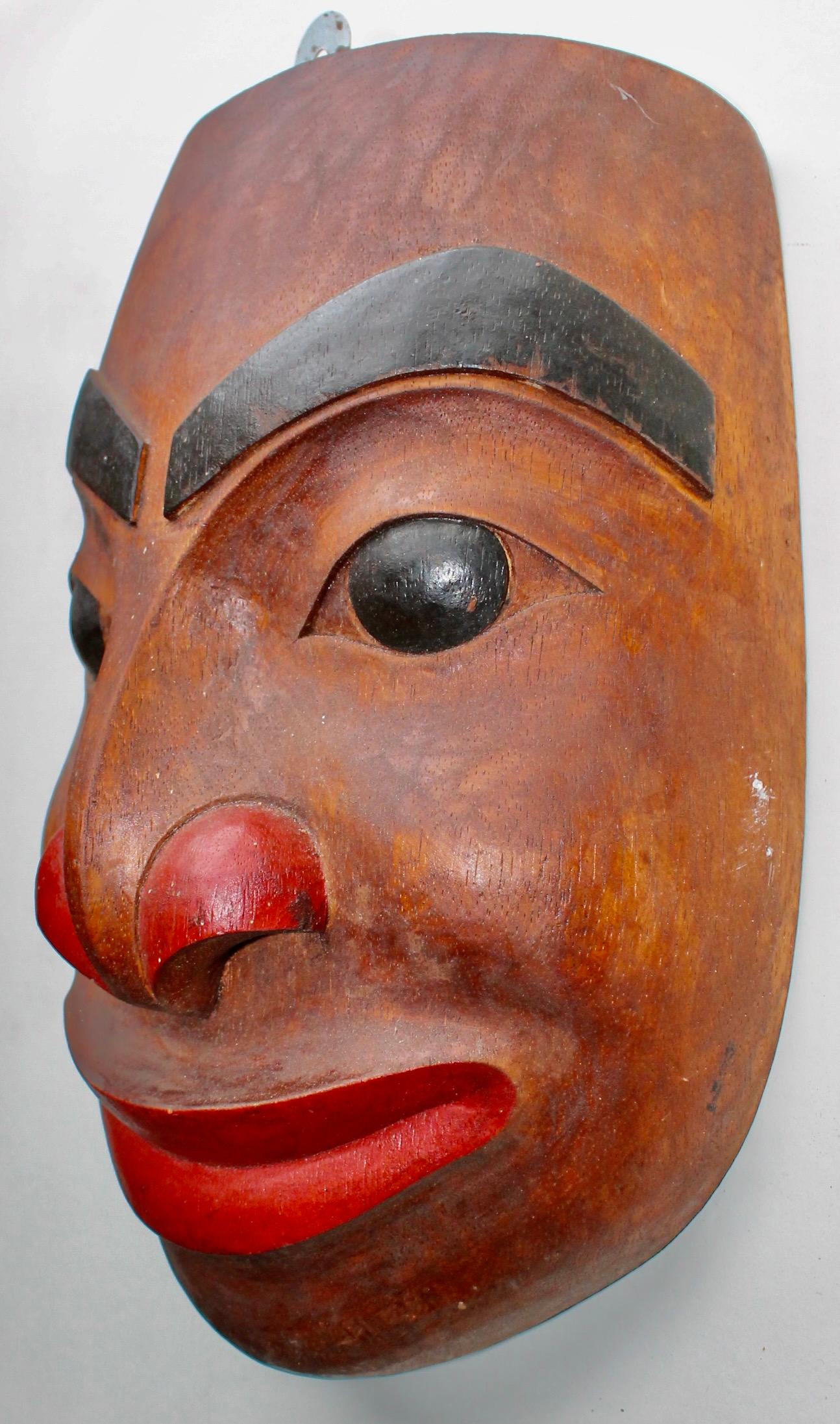 A midcentury hand crafted wood mask in traditional NorthWest Indian
Style.
