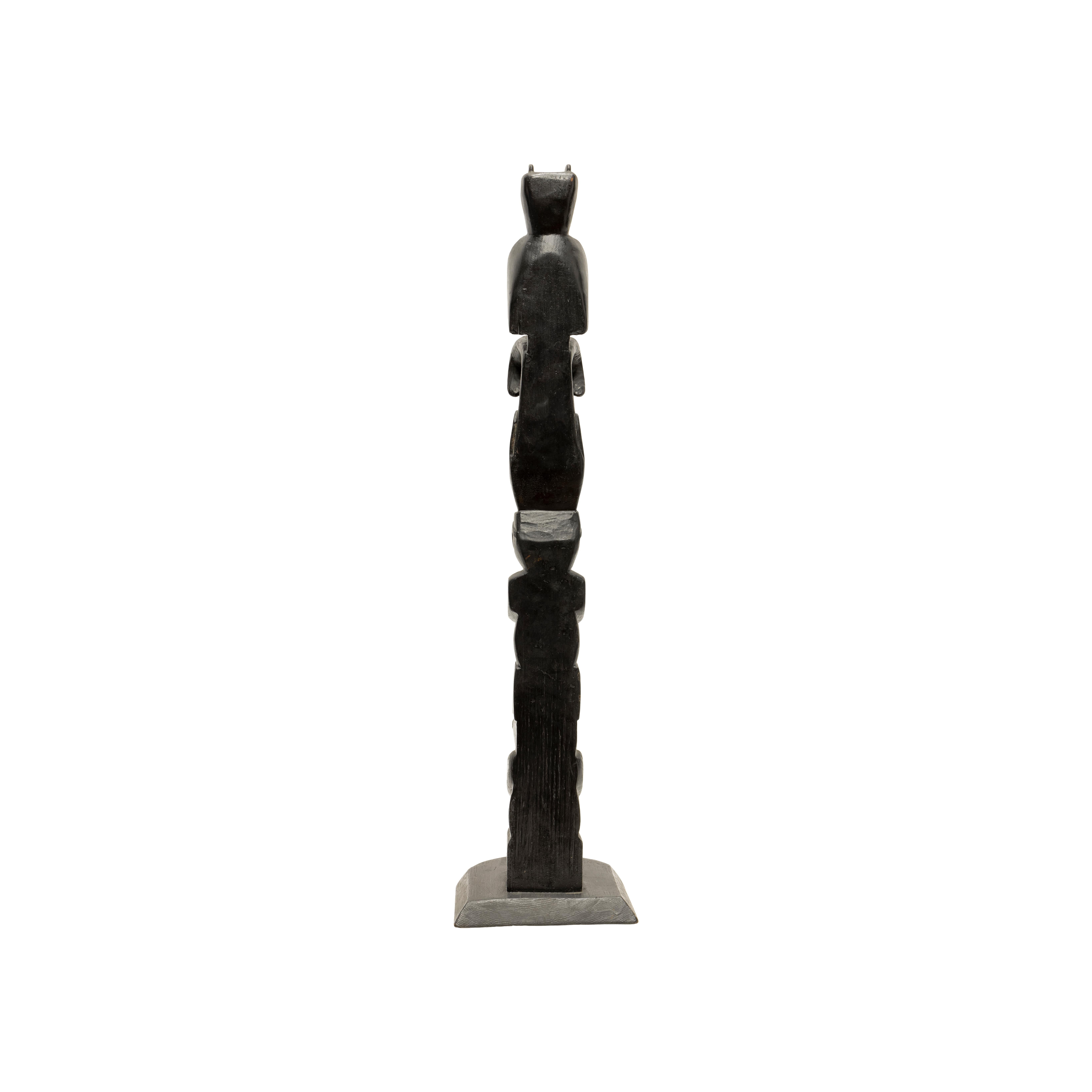 Northwest four figure totem from British Columbia. Old black paint and integral base. Great condition and just the right size. Northwest Coast art, consisting of totem poles, posts or pillars, carved with symbols or figures. They are usually made