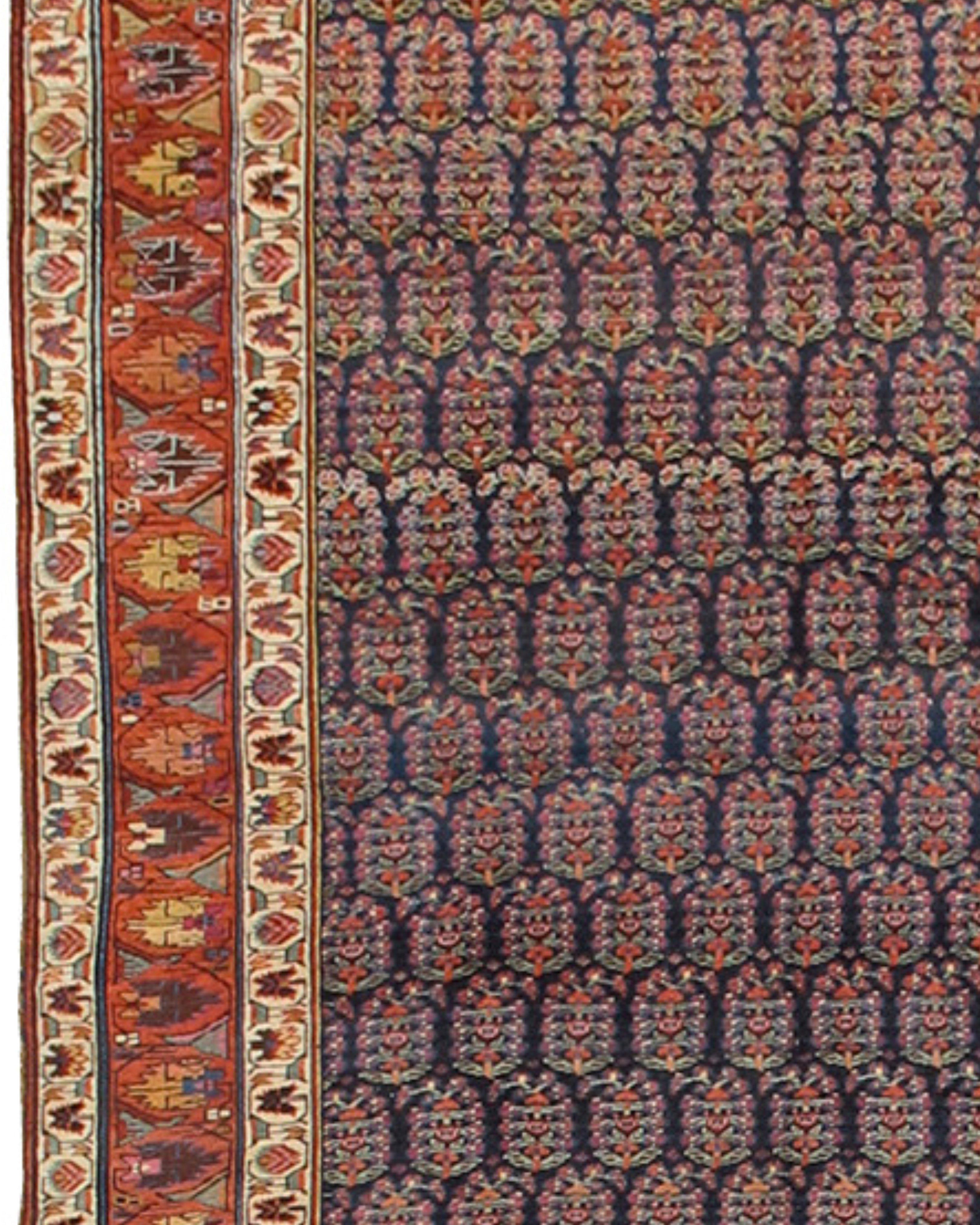 Antique Northwest Persian Long Rug, 19th Century

Woven in the Kurdish ethnic region of Northwest Persia, this magnificent corridor carpet paints rows of shimmering paisleys or boteh against a modulated blue indigo ground. Far from a static repeat
