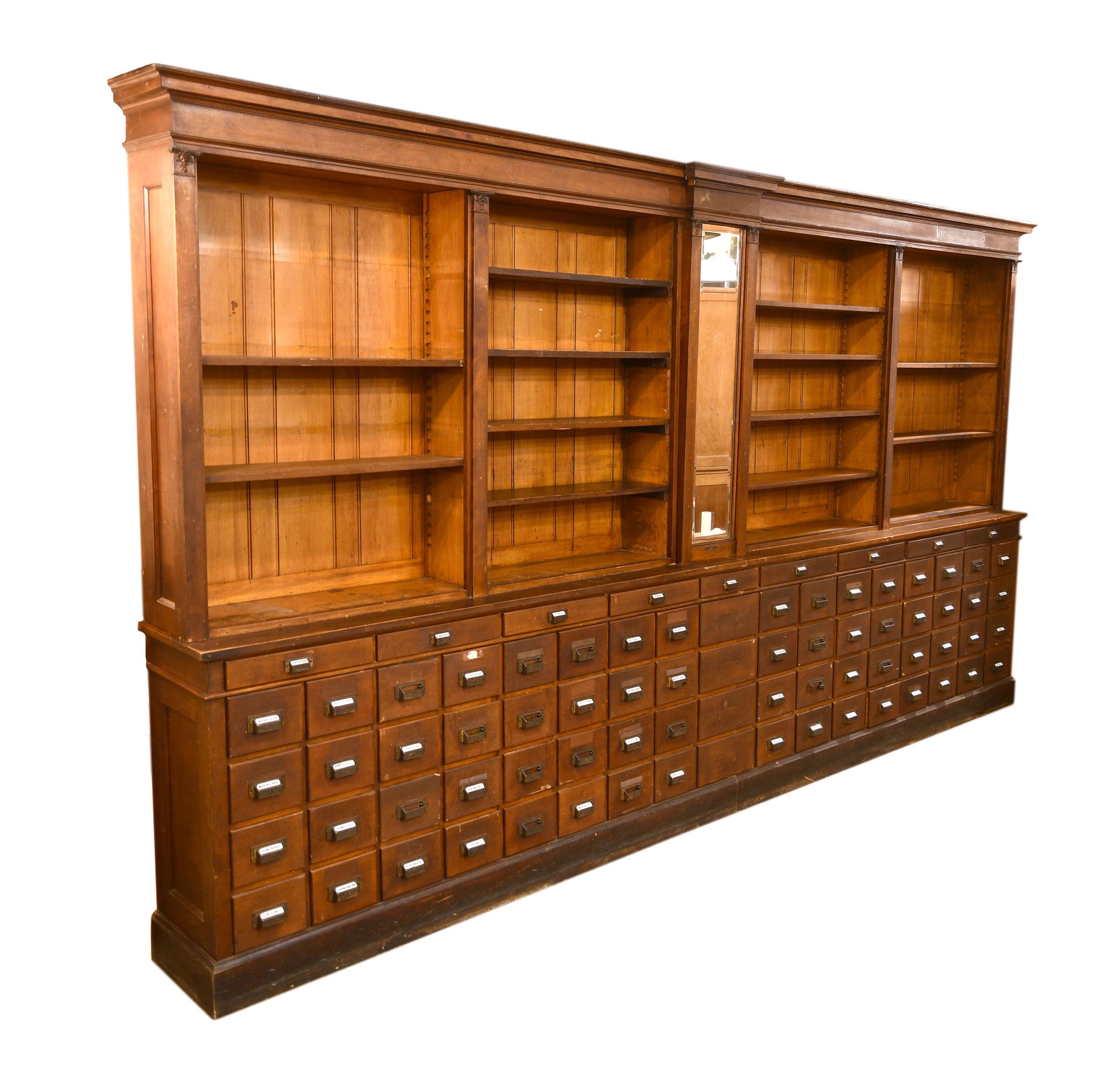 This incredible Northwestern Furniture Company apothecary cabinet features 77 drawers, 16 large shelves, and a beveled mirror in the center. Many of the drawers feature original labels, giving this cabinet even more historical character!