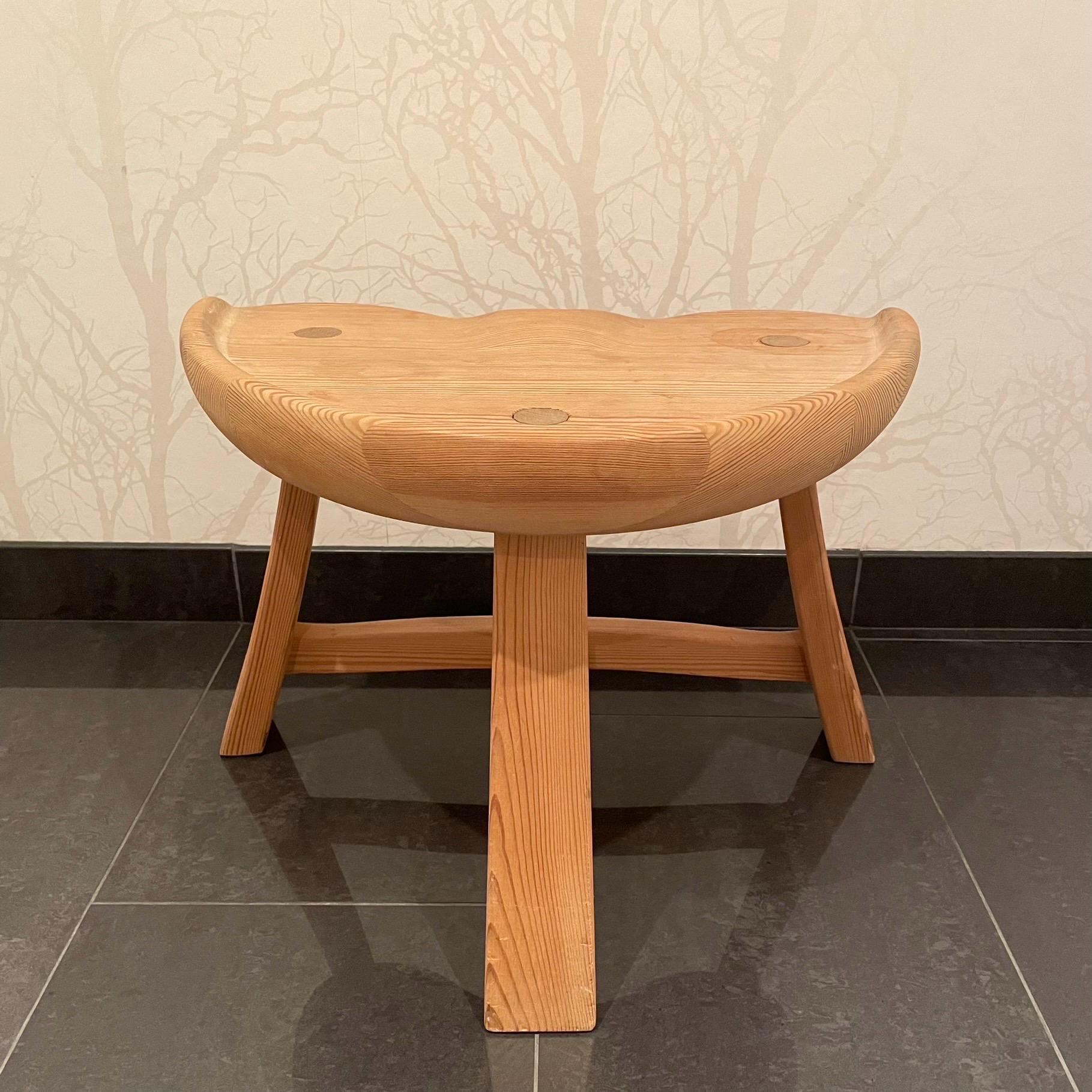 This is the Norwegian solid pine stool model nr 522. 
It comes in a stable, three legged construction with patinated untreated surface. The stool is burn marked “Krogenæs Möbler” on the underside of the seat. 

Model nr 522 was manufactured in a