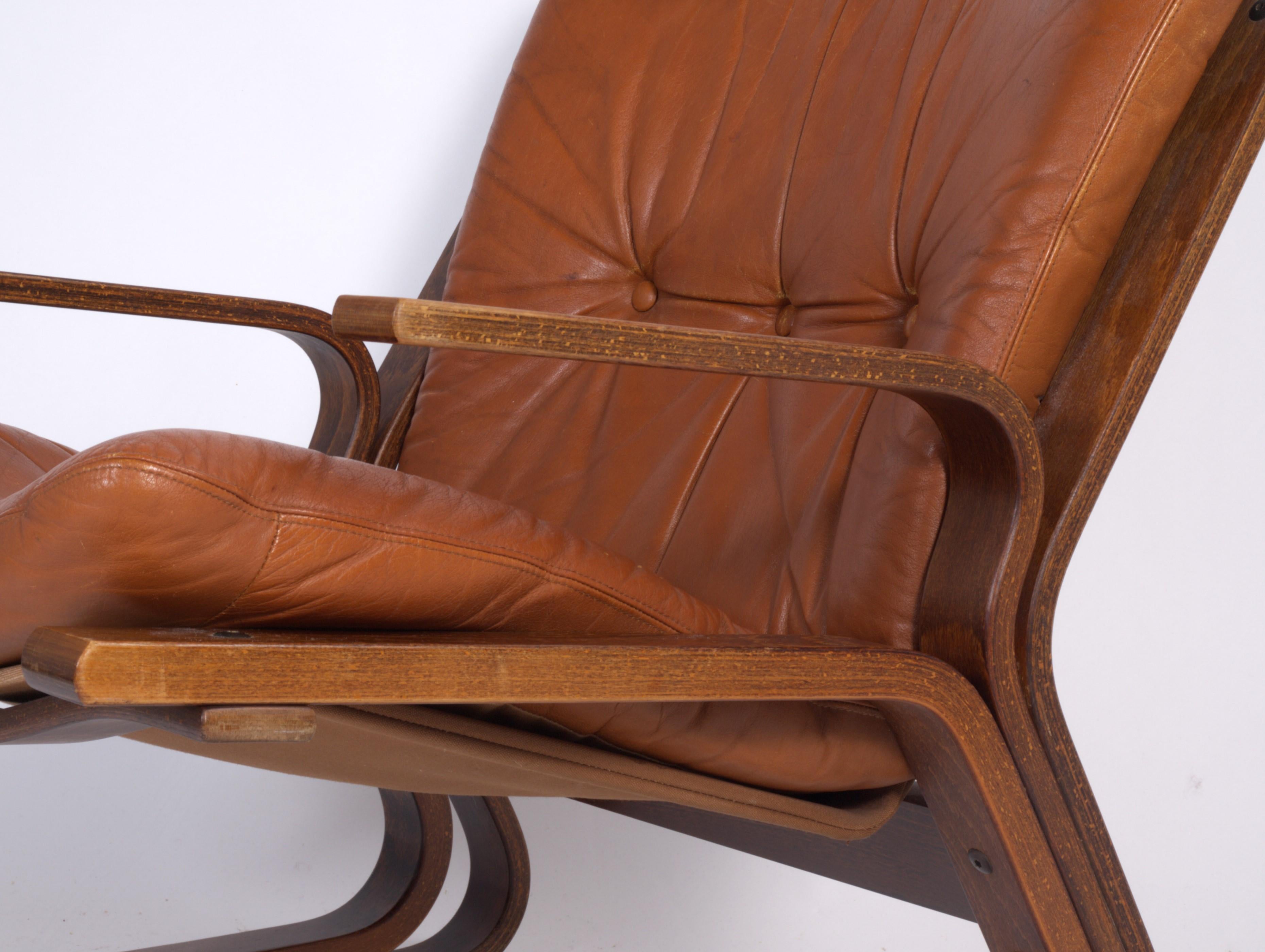 Like a Norwegian Kangaroo, this rare model gives you a soft leather seat and a bended stained beech wooden frame with suspension. A cute little armchair from Oddvin Rykken for Rybo Rykken & Co. 1970s.