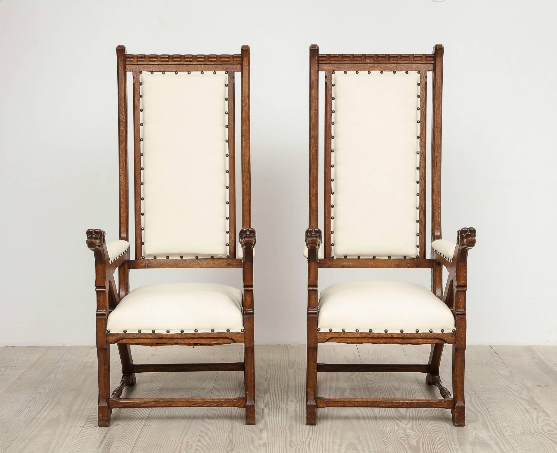 Norwegian Arts & Crafts armchairs with dog heads, a pair (two), circa 1890, origin: Norway.  Beautiful proportions, oversized Arts & Crafts / Gothic Revival armchairs with beautiful carved details such as dog's heads at the tips of each arm. 

We