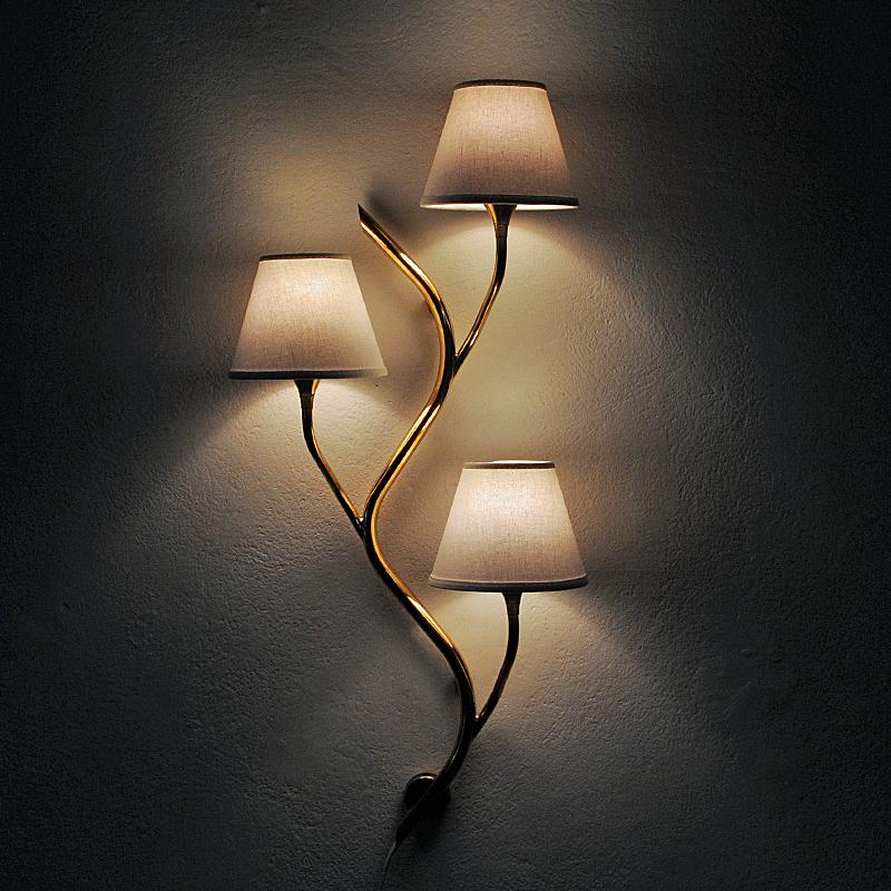 Lovely midcentury Norwegian wall lamp made in of brass by Astra Norway in the 1950s. Shaped and nicely sculpted as a tree branch with three arms and lampshades on each. Very decorative both as a pair or single.
Gives a calming beautiful light and