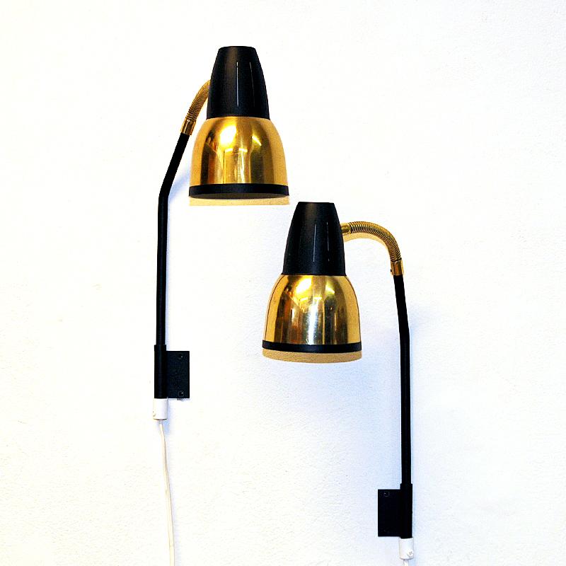 Lovely Norwegian metal and brass pair of wall lamps made by RA-GLA Belysning (established 1947) in the 1960s. These decorative black and gold colored metal wall lamps have a cone shaped shade with black top and gold bottom with a black edge. Great