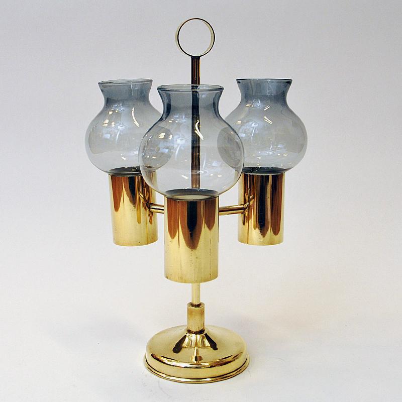 Mid-century brass candle holder with smoke colored glass shades by Odel Messing, Norway 1960s. Beautifully tulip shaped and removable glass shades. You can also use the candle holder without the shades if you wish. The holder also has a handle on