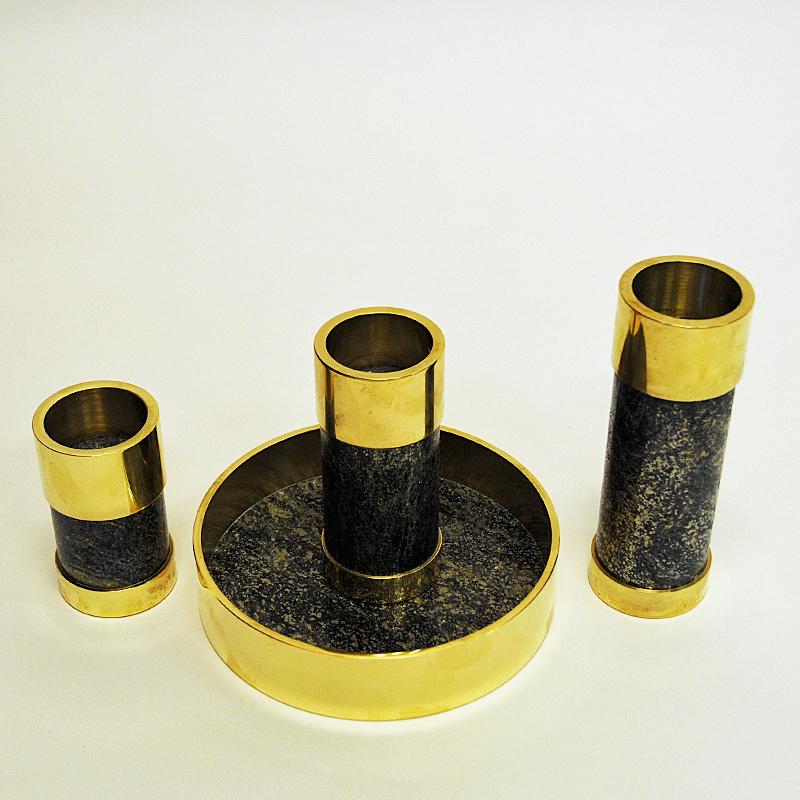 Stylish and decorative Norwegian brass and stone candleholder set with three different size candlelights on a stone dish. Underneath a blue padded fabric base labelled with: made in Norway by Saulo AS in Sulitjelma, Norway.
A Norwegian product from