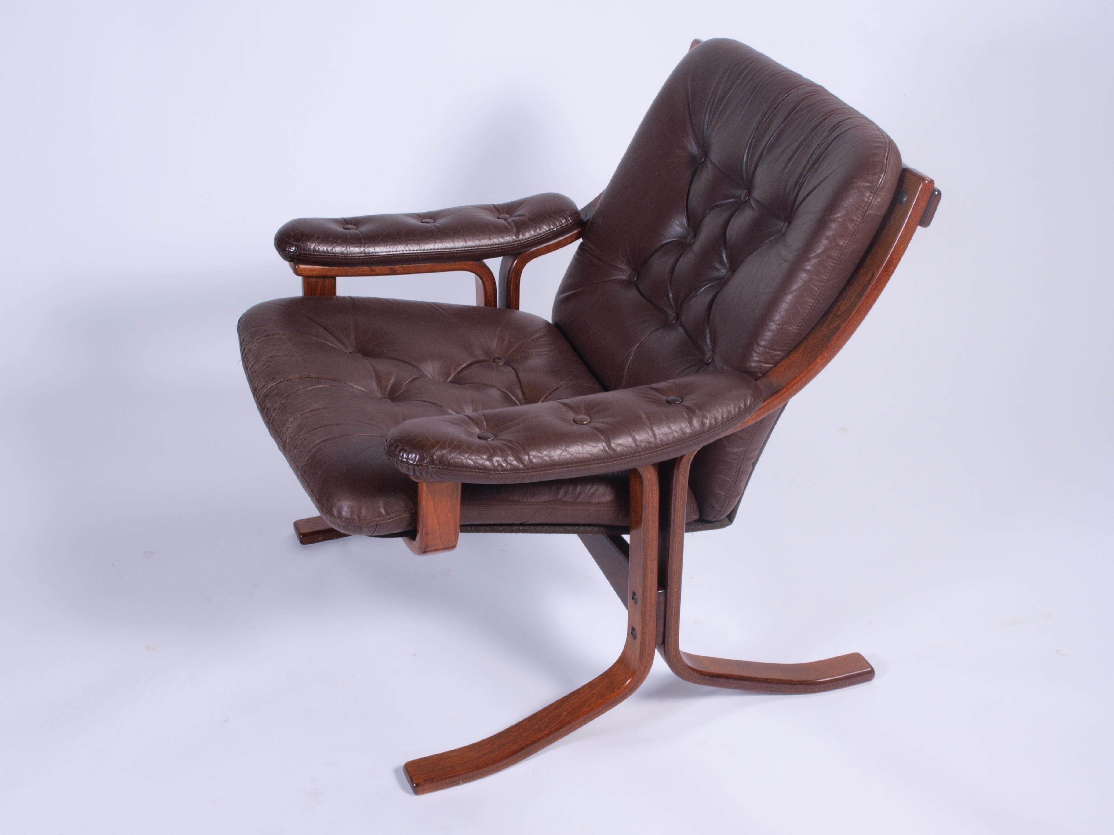 Ce fauteuil norvégien élégant et exceptionnellement confortable date des années 1970. Fabriquée en bois de hêtre teinté et verni, cette chaise présente un design unique de Jon Hjortdal pour Velledalen Mobler.

La magnifique tapisserie d'ameublement