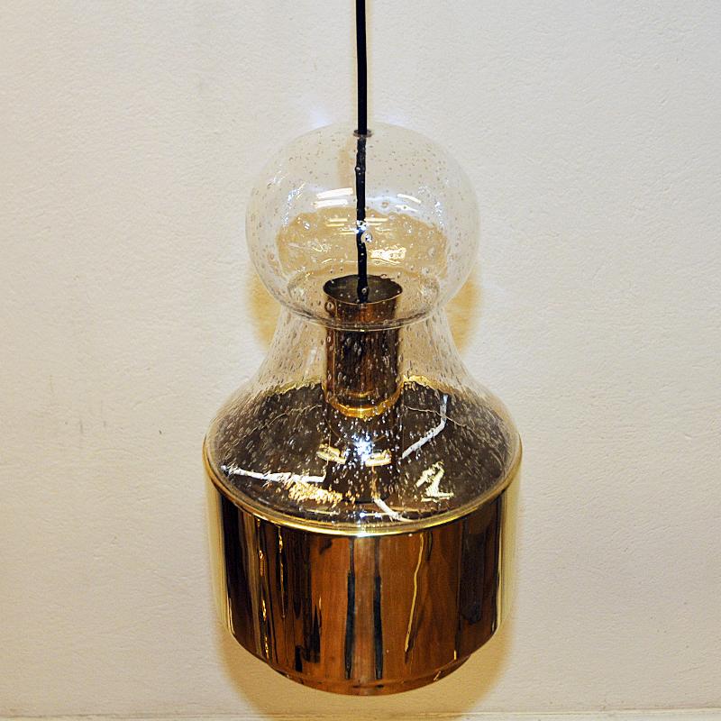 Decorative vintage glass and brass pendant lamp from the 1970s by Norwegian designer Jonas Hidle for Høvik Verk, Norway. This lamps has a mouth blown glass shade with enclosed airbubbles in the glass. The glassdome is surrounded by a solid, polished
