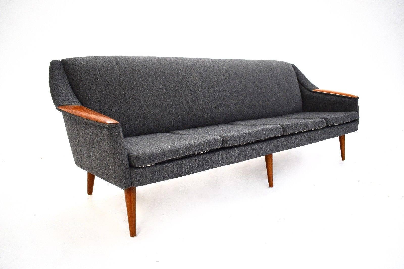 A beautiful Norwegian grey wool and teak four-seat sofa, this would make a stylish addition to any living or work area. The sofa has a padded backrest and sculptured teak armrests for enhanced comfort. The cushions are reversible and have a