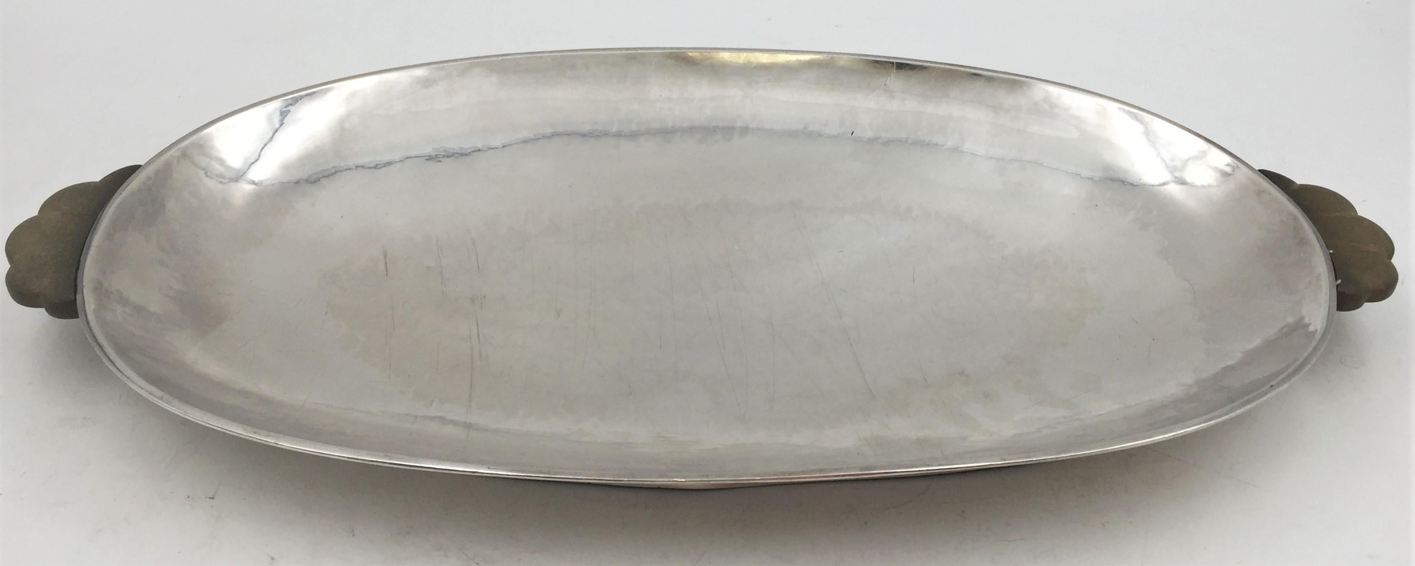 Norwegian continental 0.830 silver hand hammered centerpiece tray in desirable Art Deco style standing on a footed base with original wood handles, from the early 20th century, measuring 19'' in length by 10'' in width by 1 3/4'' in height, weighing