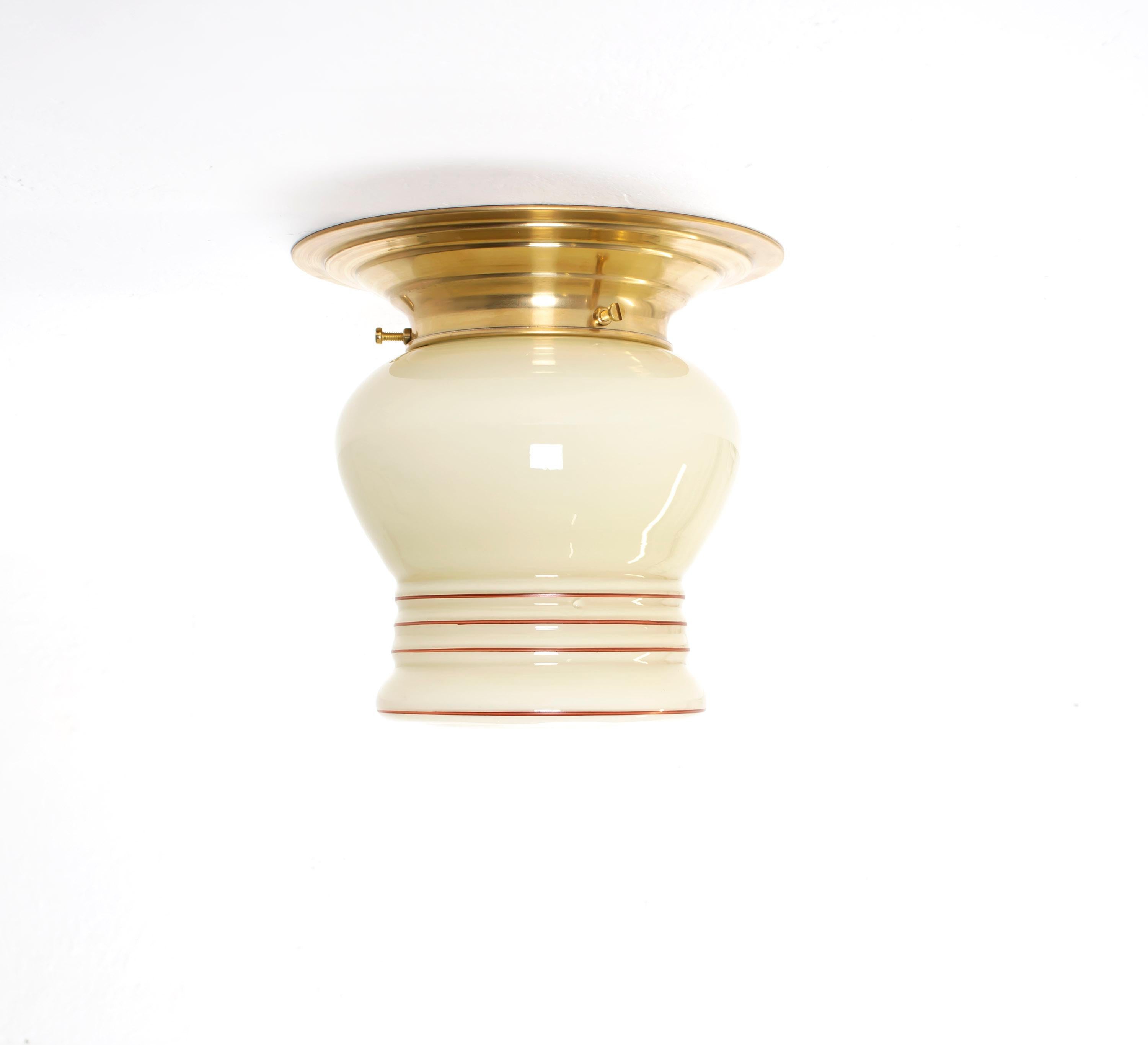 Wonderful, decorative and rare ceiling light in opaline glass with brass metal base. Designed and made in Norway from ca 1950s first half. The lamp is fully working and in very good vintage condition. It is fitted with one E27 bulb holder (works in