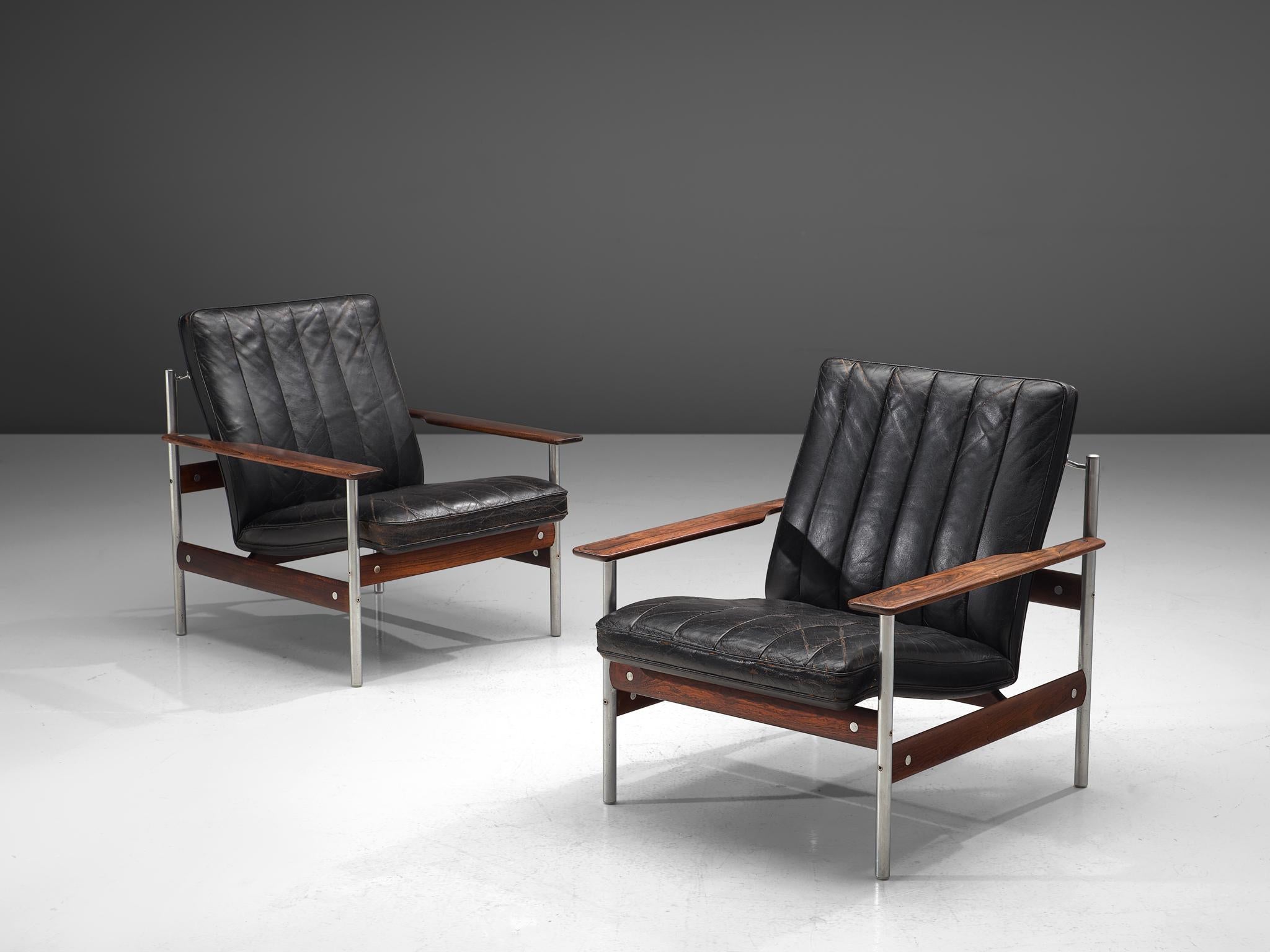Sven Ivar Dysthe for Dokke Møbler, leather, rosewood, steel, Norway, 1959.

This set of lounge chairs is designed by Sven Ivar Dysthe for Dokke Møbler. The frame of these armchairs is executed in rosewood and the legs are made out of stainless