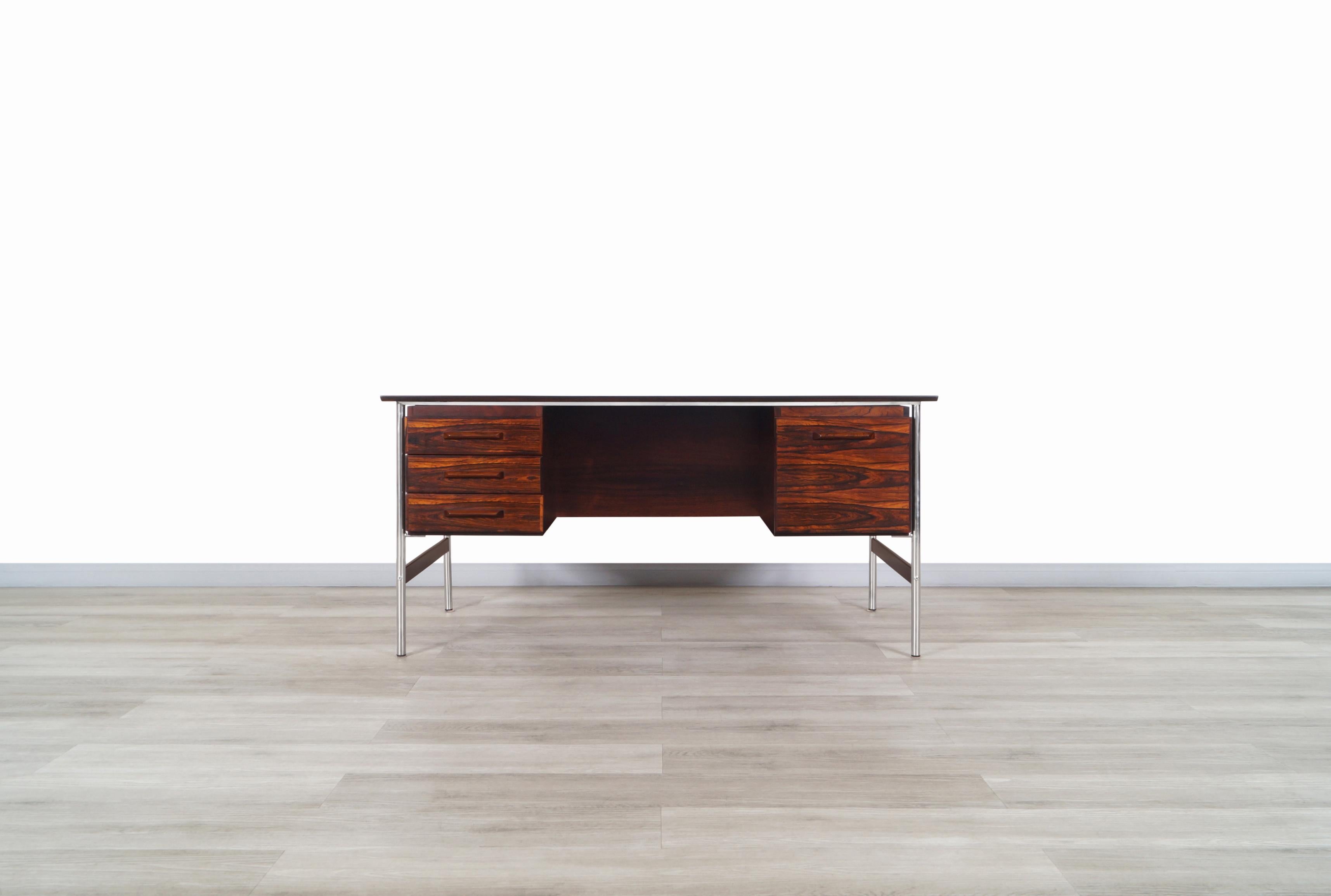 Amazing Norwegian modern rosewood desk attributed to Dokka Møbler and manufactured in Norway, circa 1960s. This desk has an executive and functional design. The desk is made of Brazilian rosewood, giving it a fascinating contrast of colors thanks to