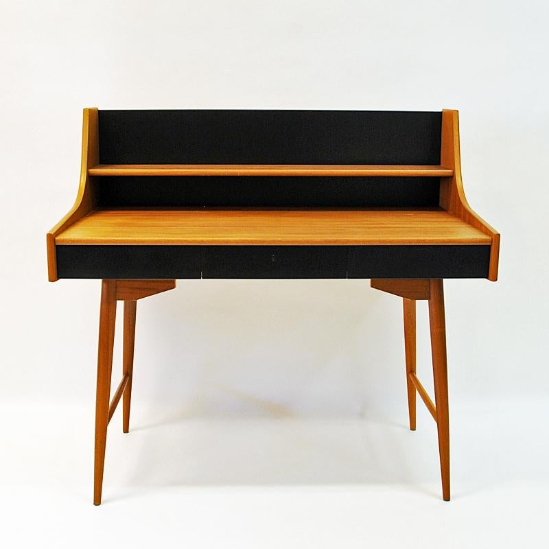The Norwegian Design Classic Ola desk (Ola pult) by John Texmon, late 1950s. Produced by Blindheim Møbelfabrikk. In mahogany and back in black melamine. 3 drawers with a key. Beautiful design and lovely patina. Measures: Total height 100 cm. Height