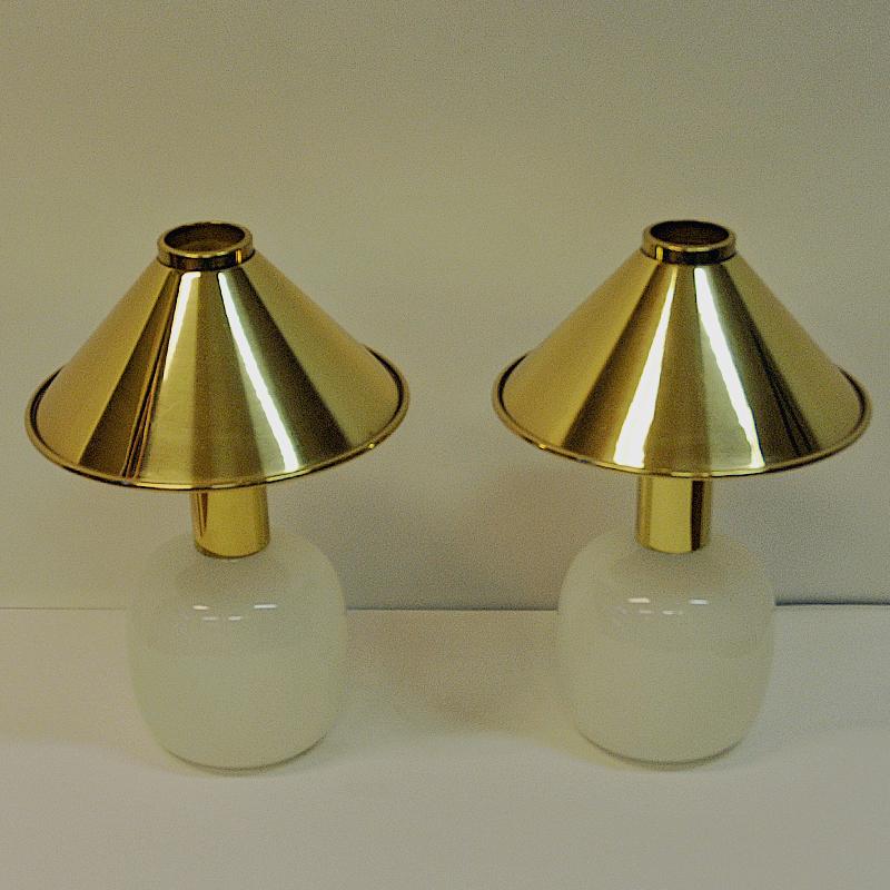 Lovely pair of midcentury table lamps from Høvik Verk, Norway 1970s. Lamp shade is placed loose on top and made of polished brass, lampfoot of clear white glass with oval shape. Decorative both as a pair or single. Gives a calming good light and