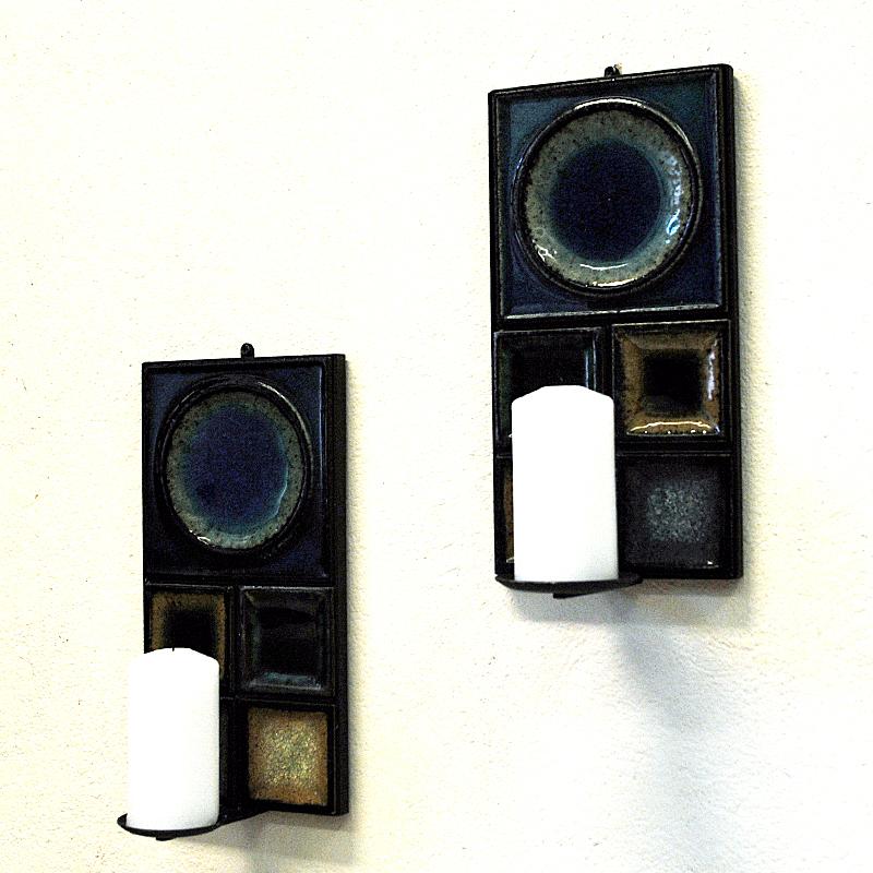 Lovely wall candleholder pair with colorful and matching ceramictiles designed by Konrad Galaaen for Porsgrund Porselænsfabrik Norway in the 1960s. The blue and beige tiles are made of glazed porceleaine mounted on a black metal base holder. For