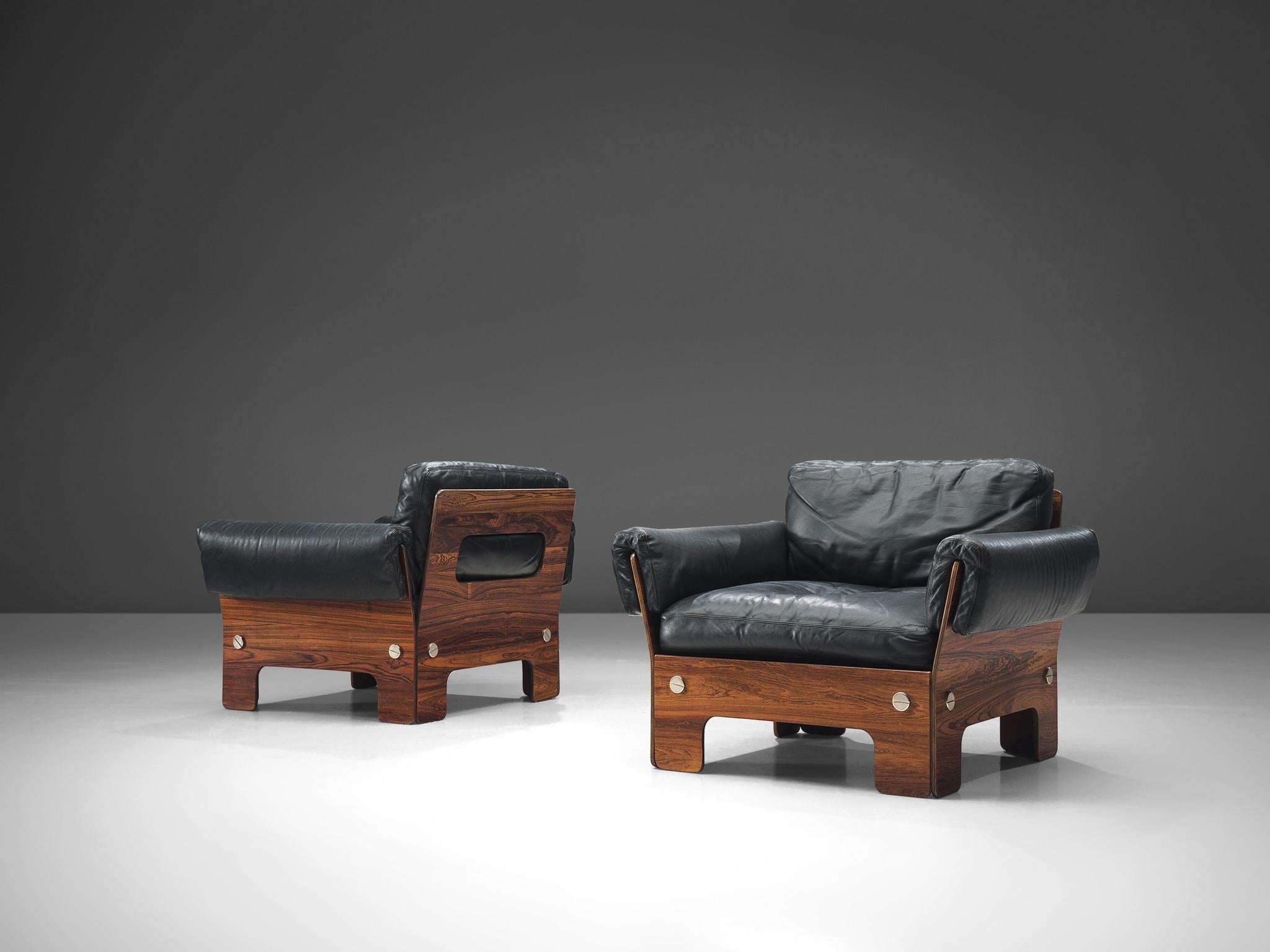 Lounge chairs, rosewood and black leather, Norway, 1960s. 

These lounge chairs present very comfortable elements. The boxy look of the lounge chairs is due to its square and rectangular shape, which creates an potent look. The cushions are