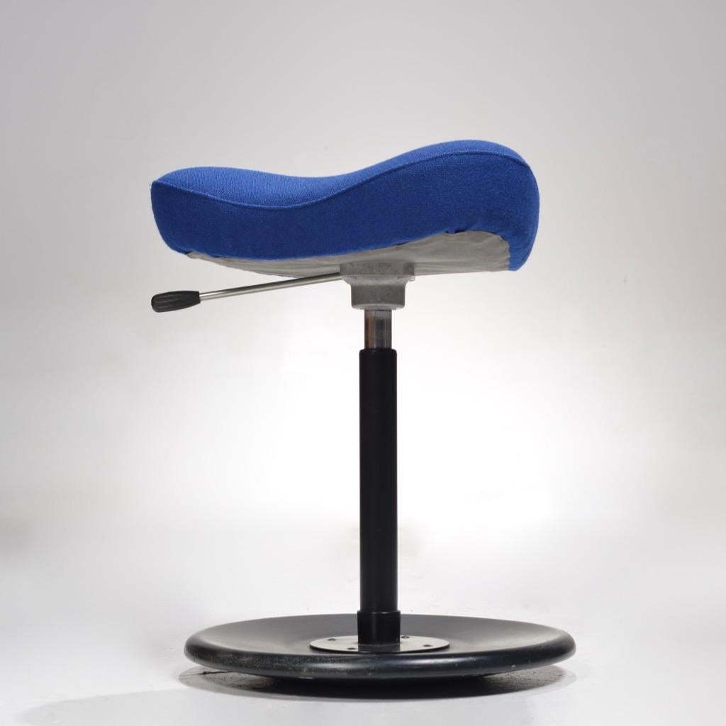 Norwegian triangular work stool with cobalt blue upholstery.
This unique triangular seat shape is incredibly comfortable, and encourages users to sit in a saddle posture - lowering the thighs and opening the hips while putting the spine into a