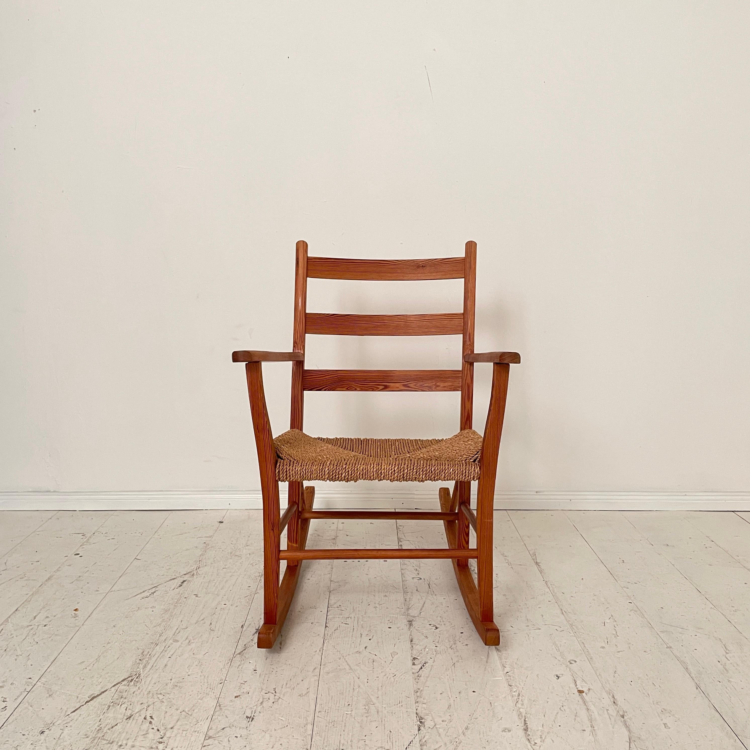 Dieser schöne und sehr bequeme norwegische Schaukelstuhl wurde von Aksel Hansson in den 1930er Jahren hergestellt und entworfen. Der Stuhl ist aus massivem Kiefernholz gefertigt und die Sitzfläche besteht aus geflochtenem Seil.
Ein einzigartiges