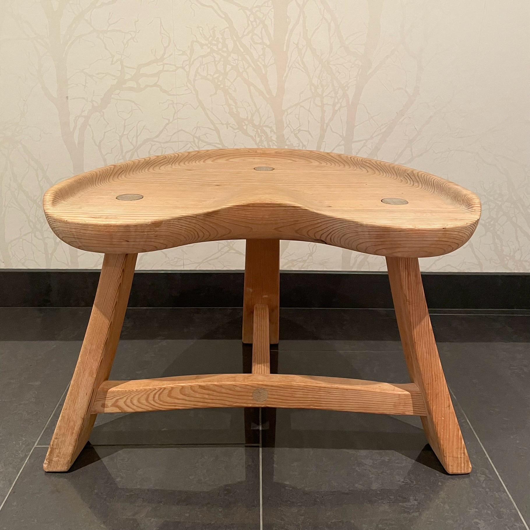 This is the Norwegian solid pine stool model nr 522. It comes in a stable, three legged construction with patinated untreated surface. The stool is burn marked “Krogenæs Möbler” on the underside of the seat. 

Model nr 522 was manufactured in a