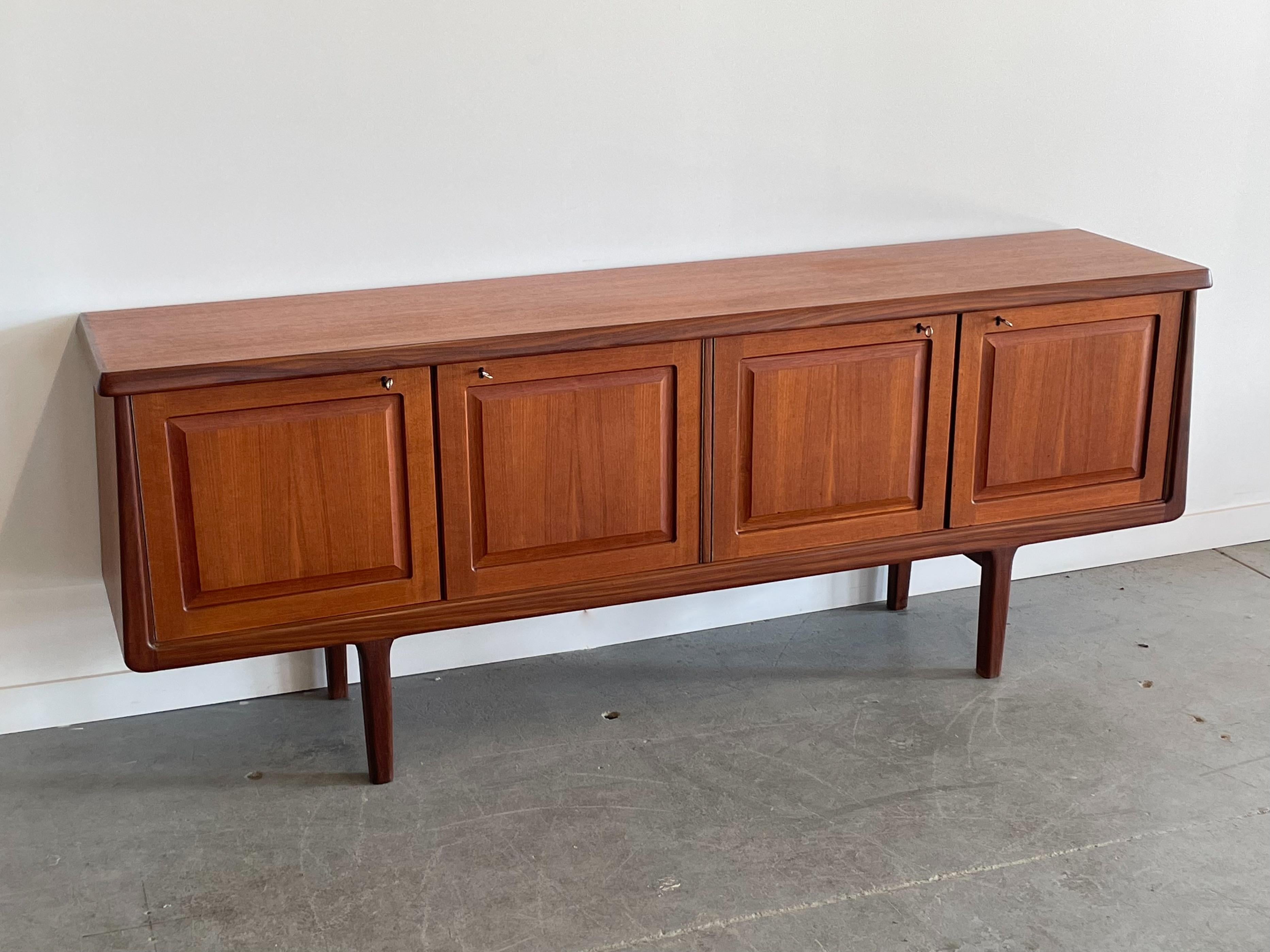 Beautifully crafted Norwegian teak + afrormosia credenza by Arnt Sorheim for Broderne Sorheim. This exceptional piece features a unique form with a thick profile top. A solid afrormosia edge detail carries along the sides and bottom of the cabinet.