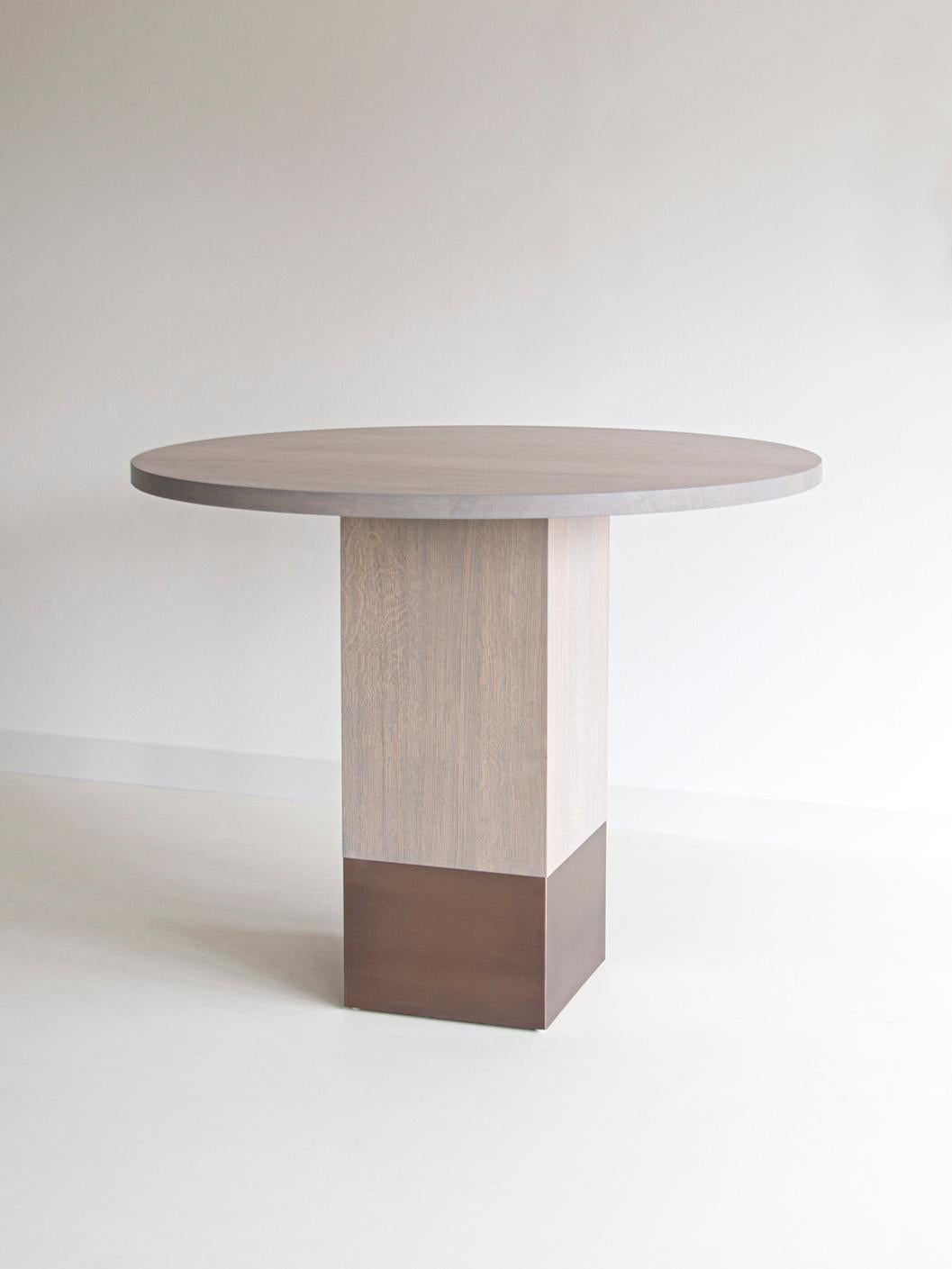 Nota Bene bar table by Van Rossum
Dimensions: D140 x 140 x H110 cm
Materials: Oak, brass.

The wood is available in all standard Van Rossum colors, or in a matching finish to customer’s own sample.
Detailing is available in stainless steel or