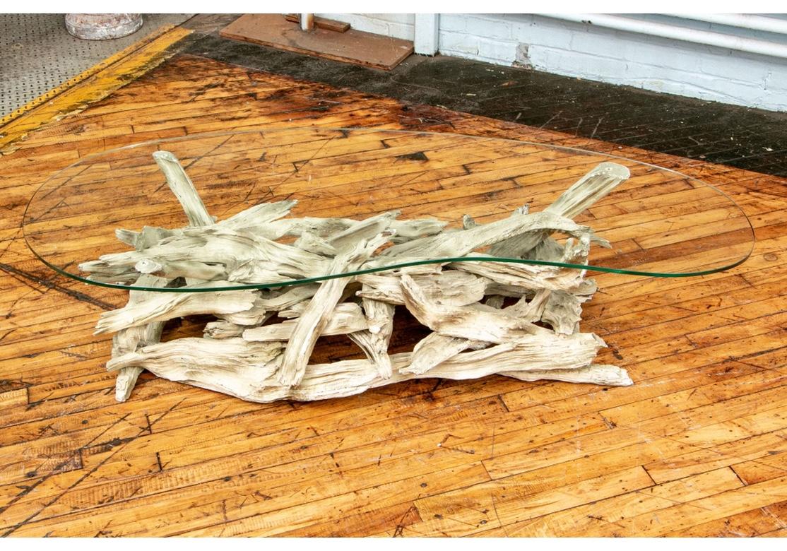 A Mid-Century found driftwood cocktail table with particularly fine and long form. A pale gray driftwood shape with a kidney shaped glass top.
Measures: Length 59