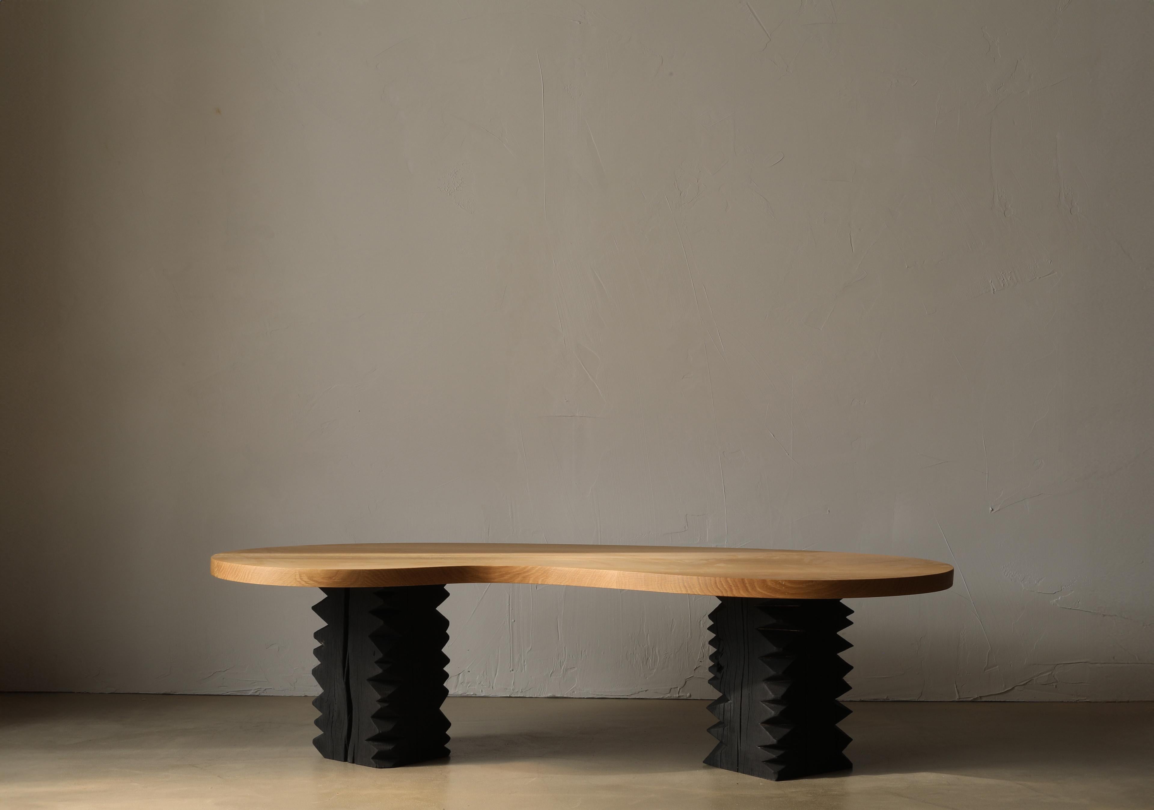 The Notch II coffee table is built from two solid pedestal legs and a large bean-shaped white oak top.

This collection finds its foundation in ‘cribbage’,  a rough-cut lumber used to build support structures called ‘cribs’ in coal mines. This