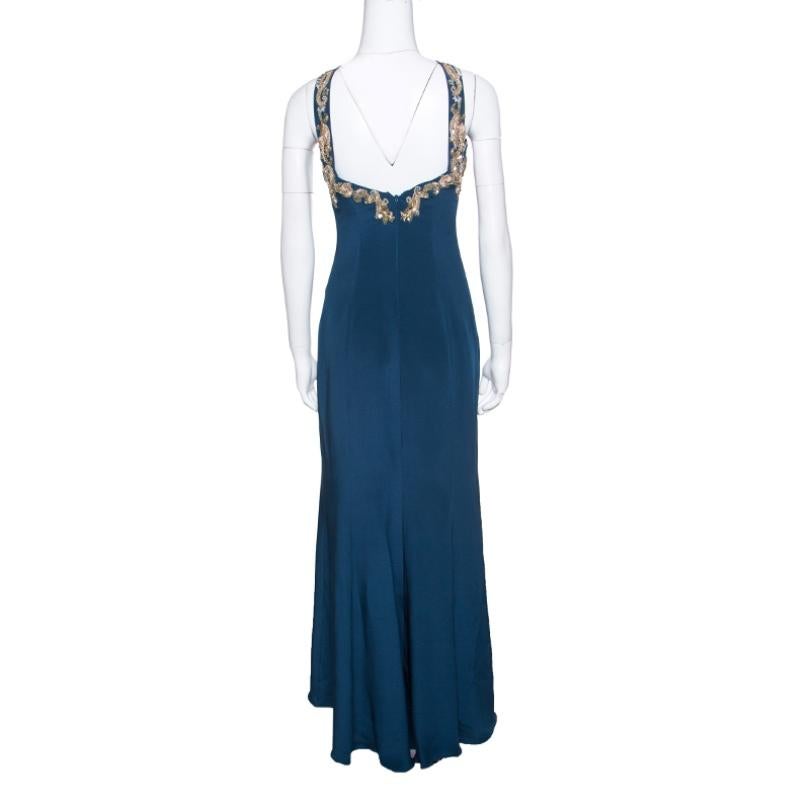 You'll find reasons to wear this stunning Notte by Marchesa dress. This peacock blue maxi dress is made of 100% silk and features a flattering silhouette. It flaunts a cross strap neckline with beautiul sequins, beads and crystals adorning the