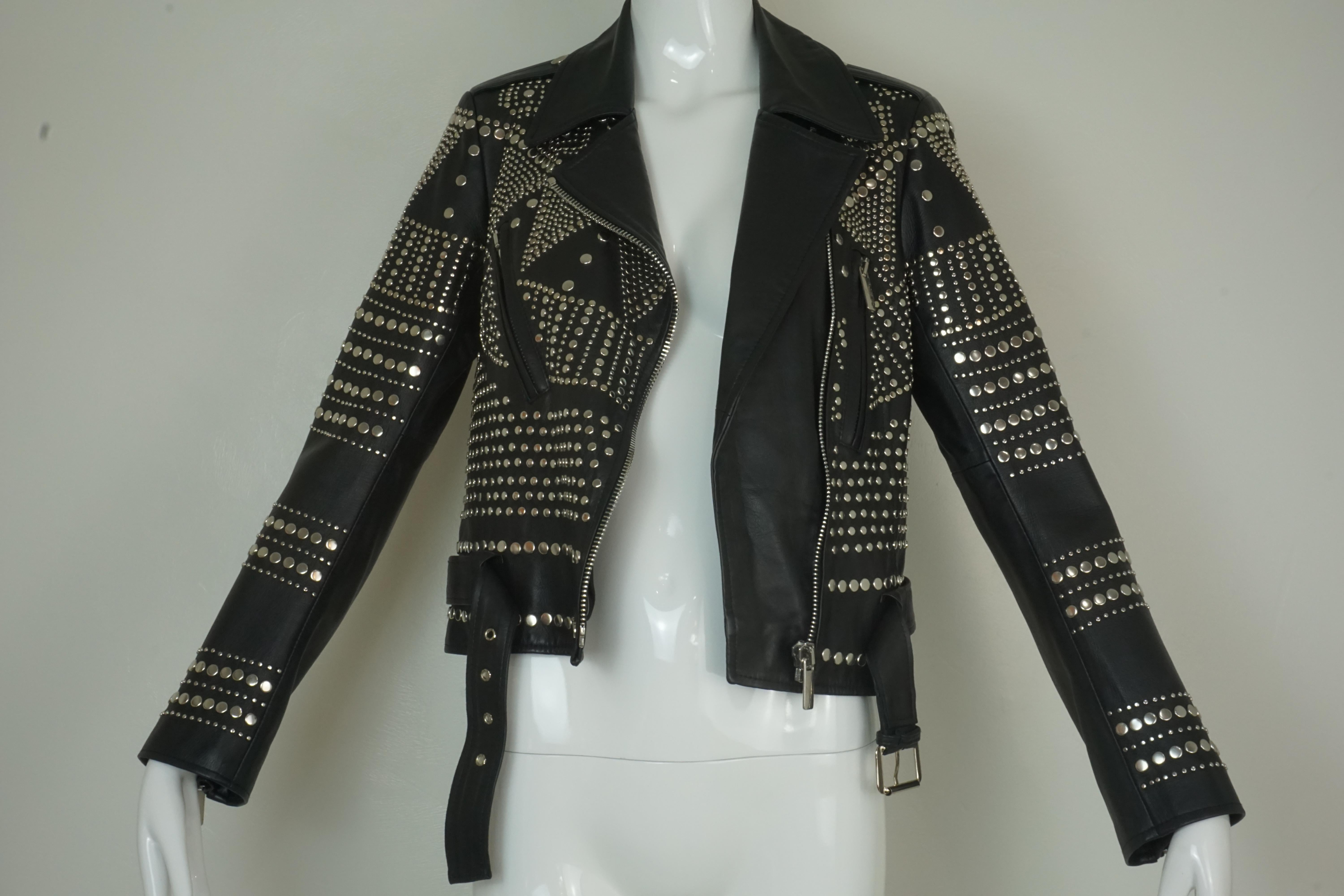 Nour Hammour Paris Studded Black Leather Motorcycle Jacket. Patterned silver studs at front, half belt with silver metal buckle, Full zip closure at front, quarter zippers at sleeves. 100% Lambskin treated in France, rayon lining. Size 38/6.  

Foxy