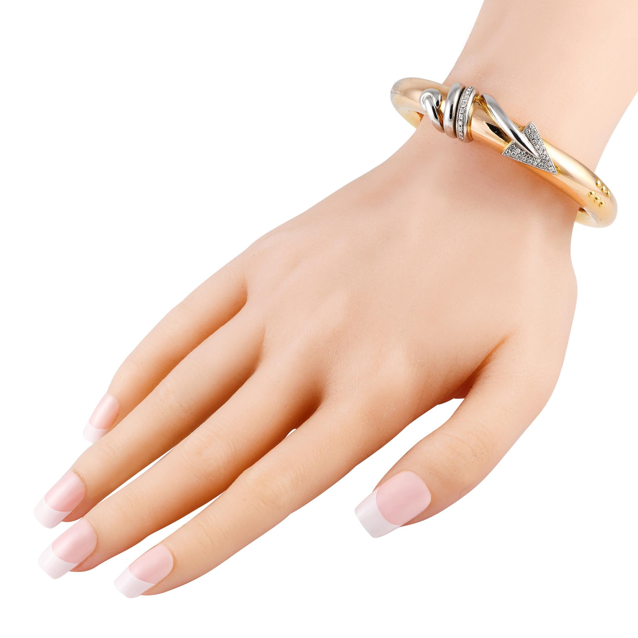 This bi-colored bracelet is anything but ordinary. Expertly made by Italian jewelry brand La Nouvelle Bague, this piece of jewelry features a rigid bracelet in solid 18K yellow gold. A white gold arrow with diamond embellishment coils itself into